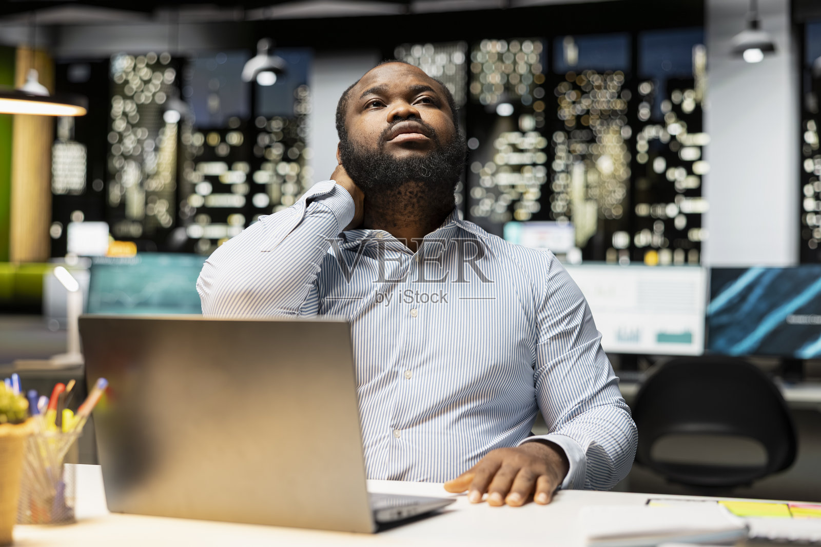 一名黑人男性专业人士正在为缓解颈部僵硬而进行自我按摩照片摄影图片