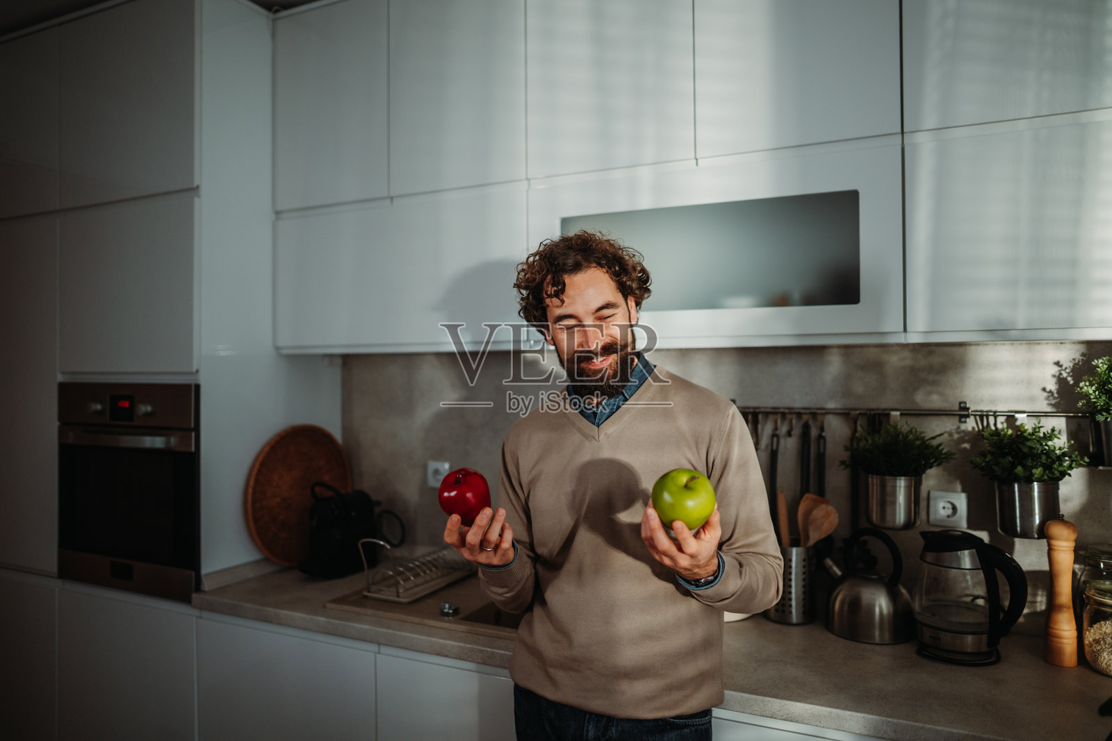 男人在红苹果和绿苹果之间选择照片摄影图片