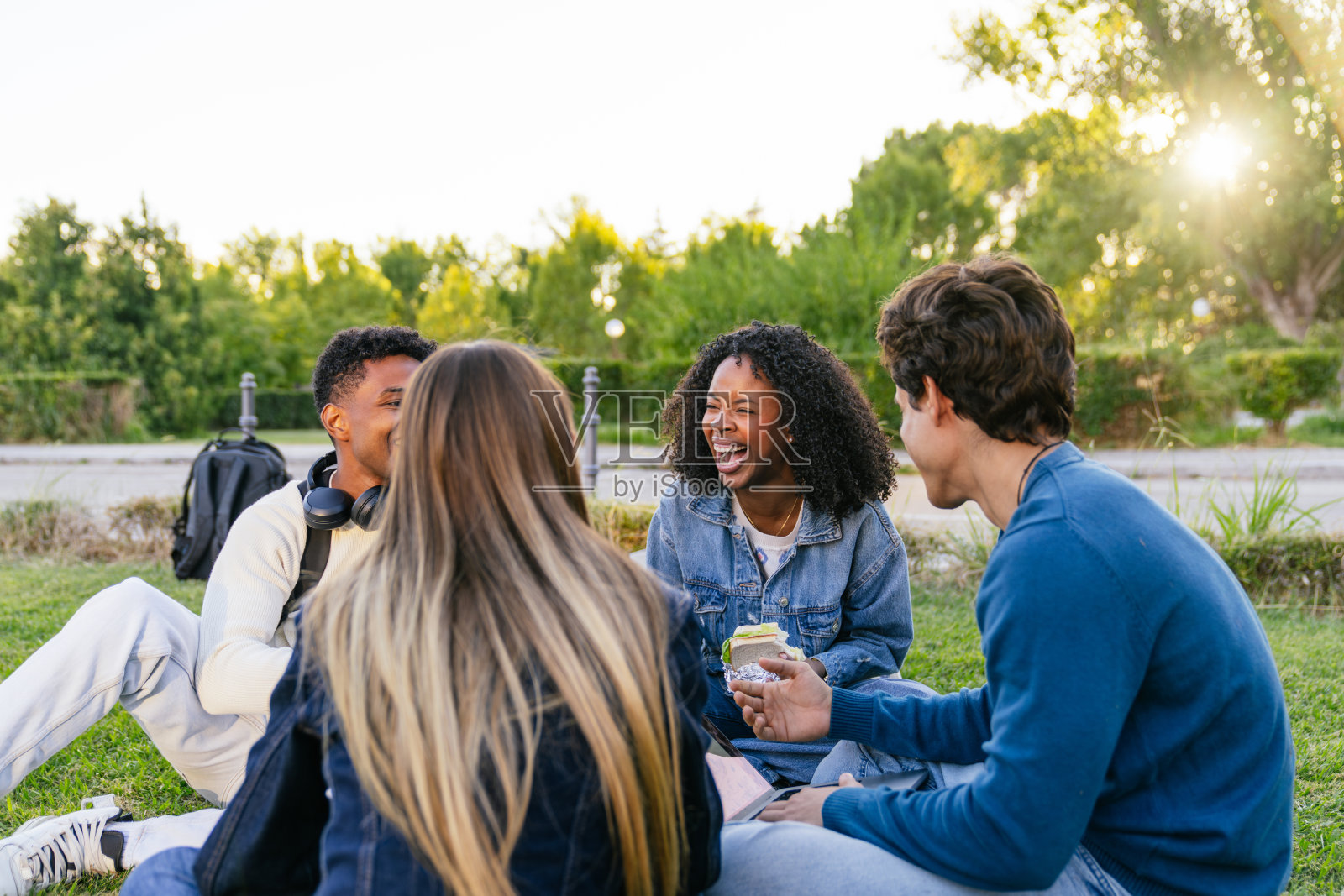 不同种族的学生在大学校园草坪上开怀大笑照片摄影图片