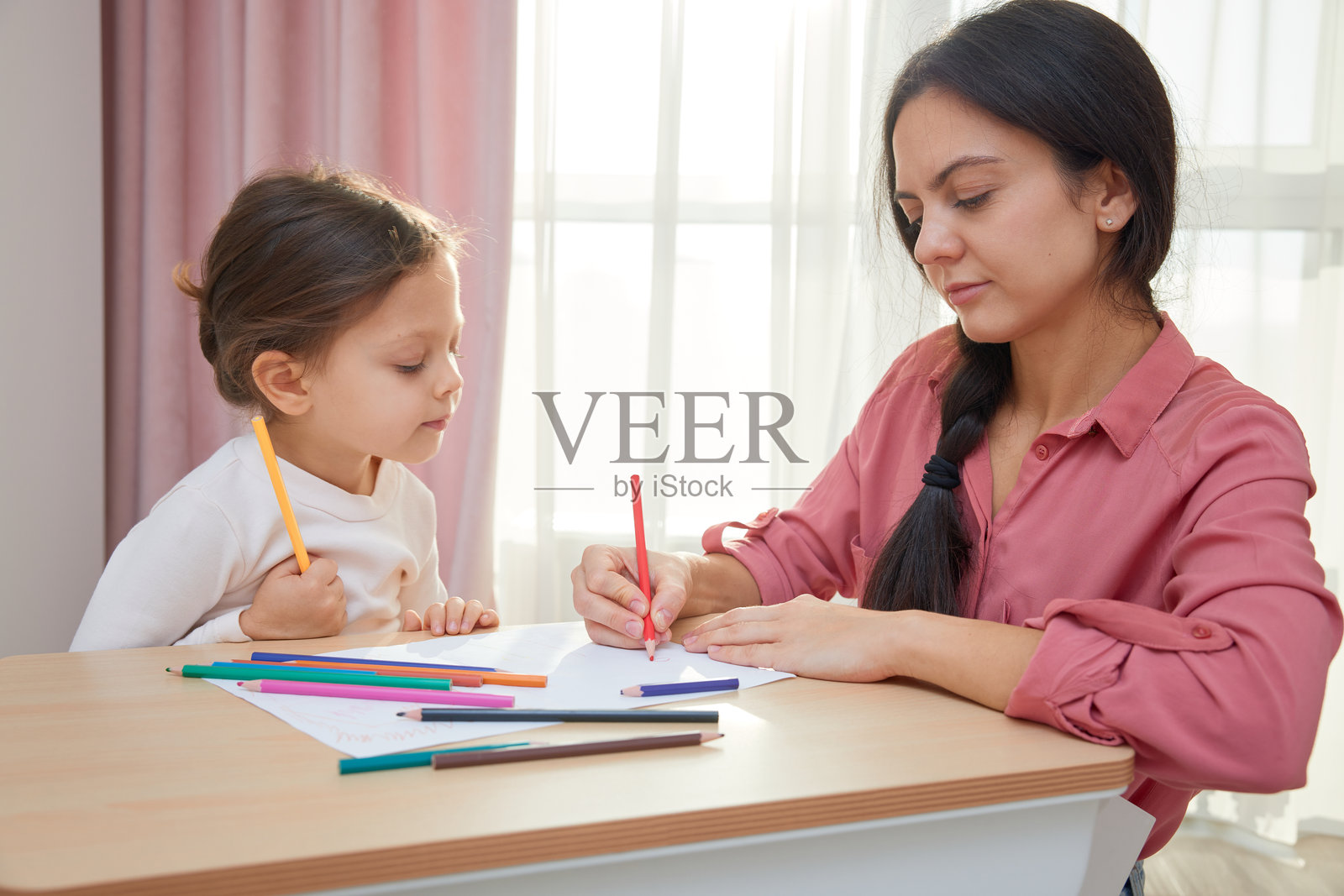 妈妈帮助女儿一起画画和学习照片摄影图片