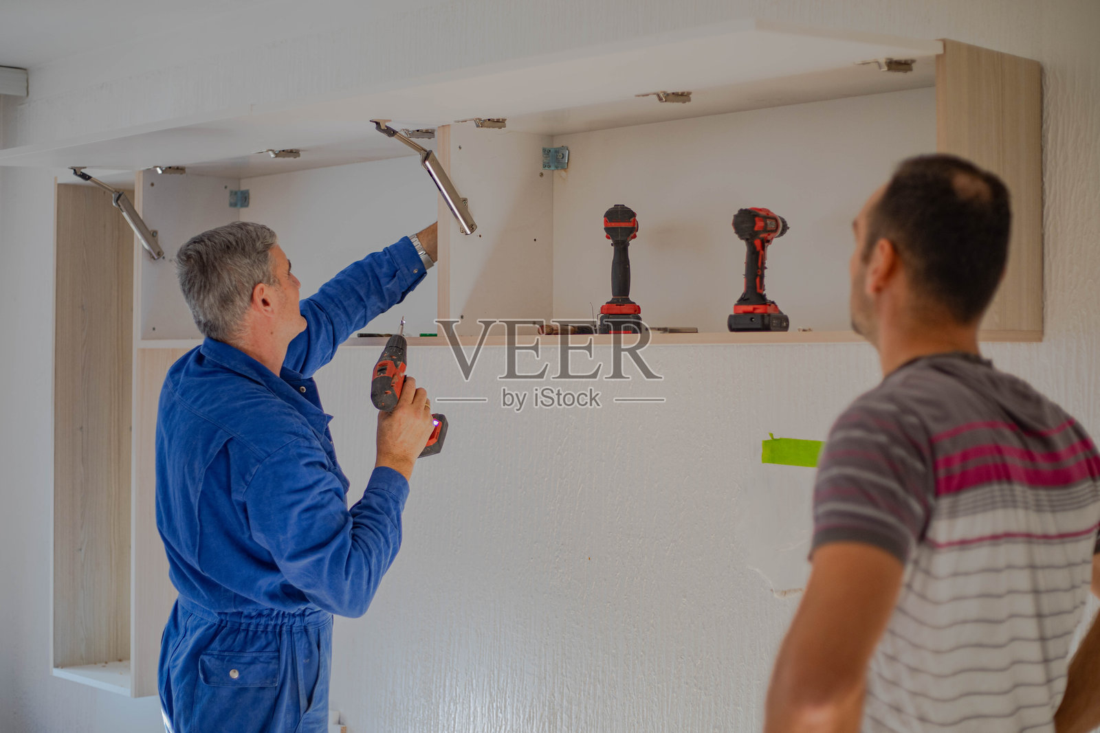 在公寓里放置家具，木匠们正在组装架子照片摄影图片