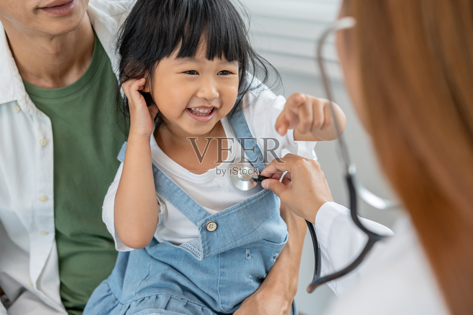 儿科医生正在根据儿童的年龄检查其发育情况，医生鼓励孩子进行活动，关注智商、情商、适合年龄的学习活动及促进，期待照片摄影图片