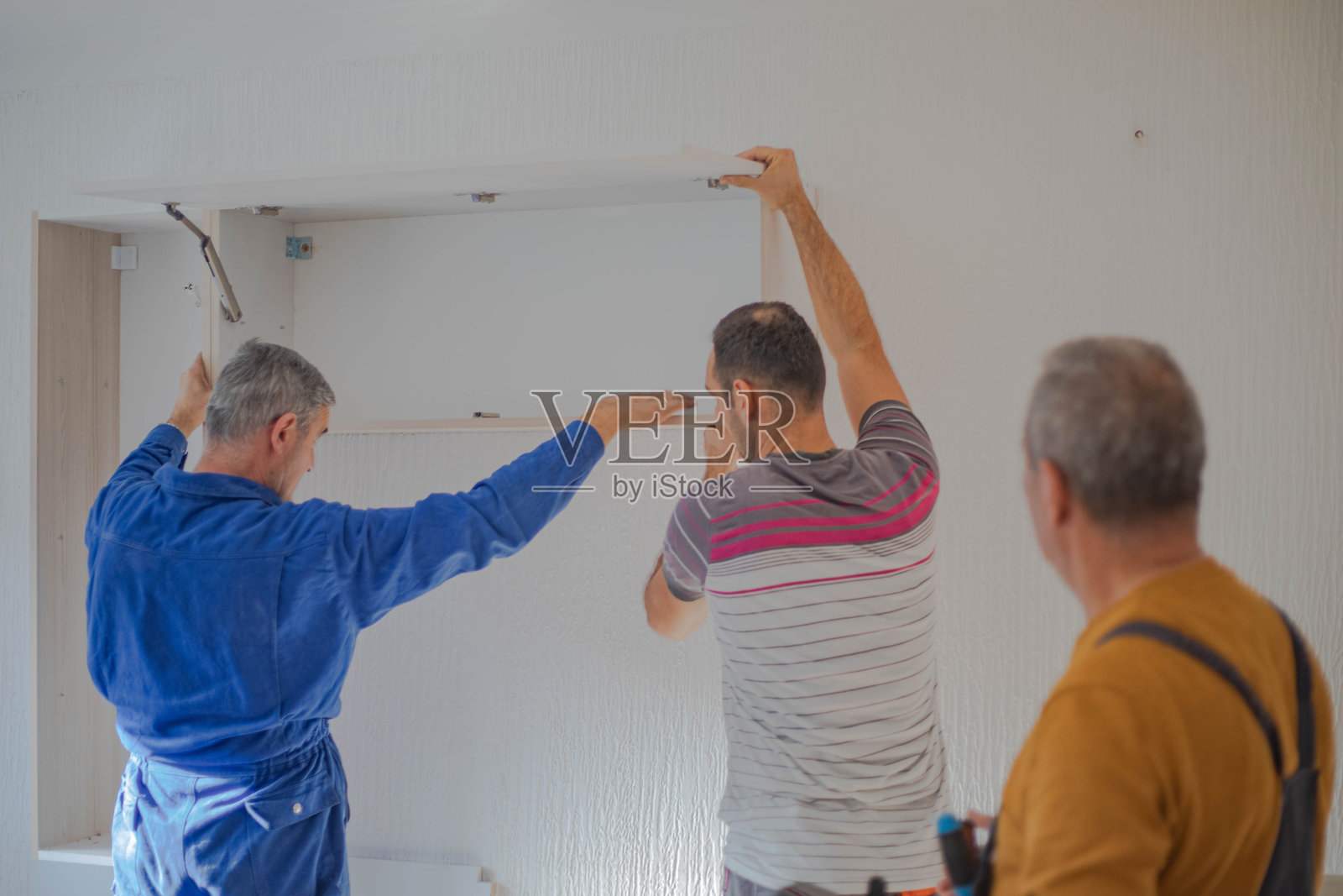 在公寓里摆放家具，木匠们正在组装架子照片摄影图片