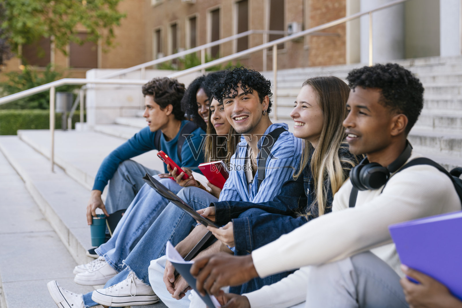 不同种族的学生们在大学校园的楼梯上一起学习照片摄影图片