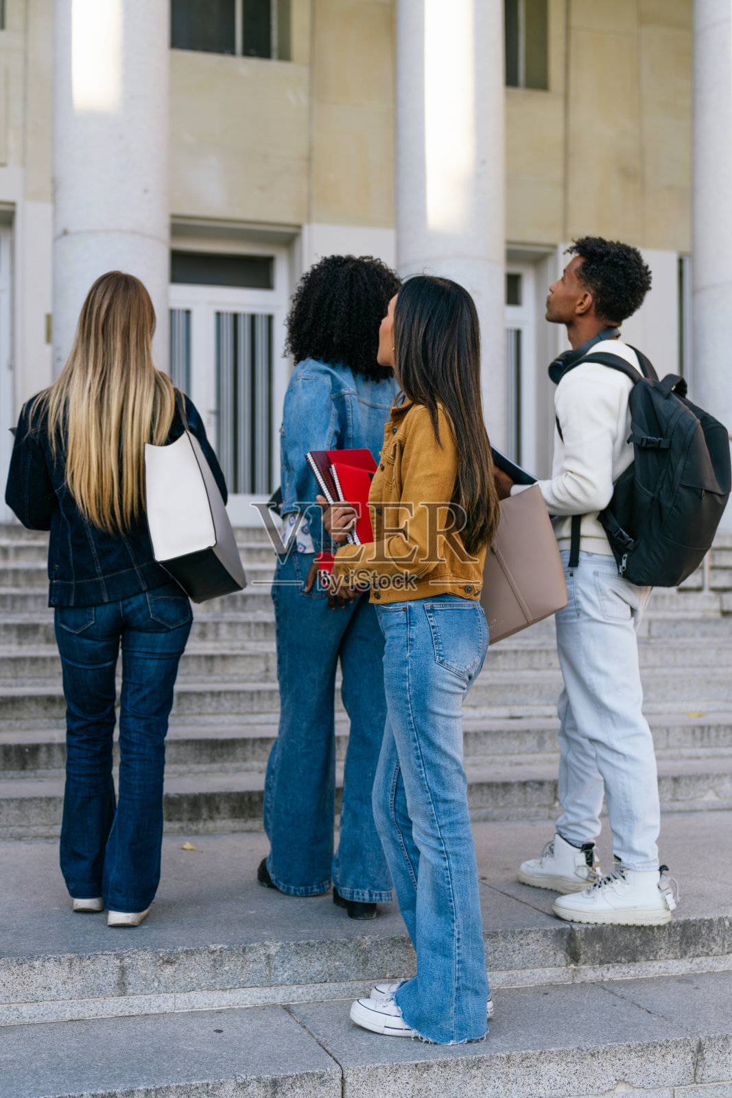 不同背景的学生在大学校园楼梯上行走照片摄影图片