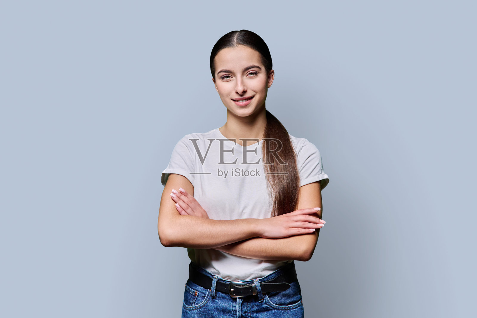 身穿白色T恤的自信美丽少女肖像，背景为灰色照片摄影图片