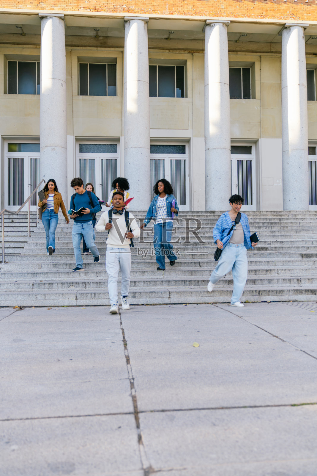 一群来自不同背景的学生正在大学校园的楼梯上行走照片摄影图片