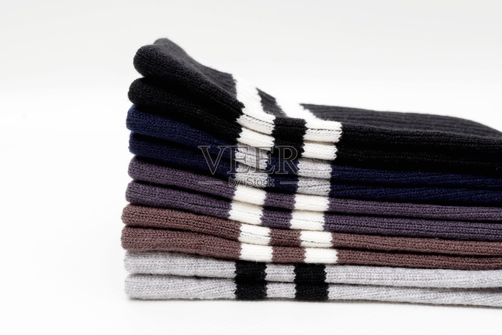 白色背景上叠放着各种颜色条纹的棉袜照片摄影图片