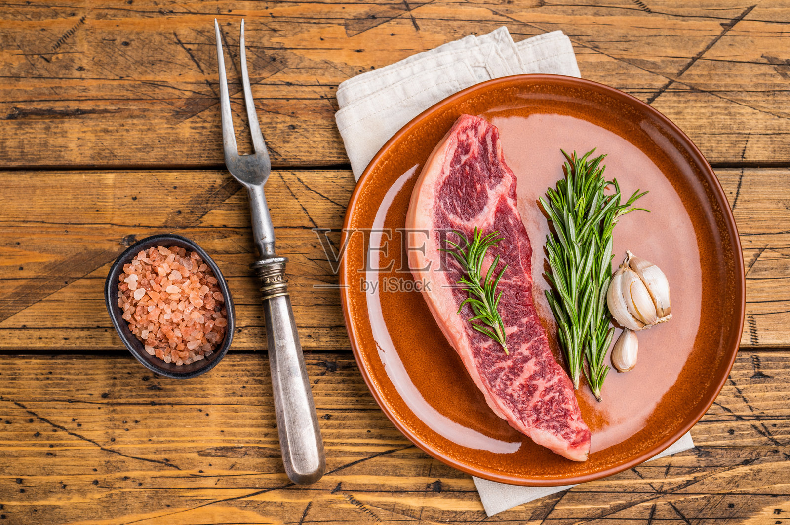 生西冷牛肉牛排，色泽鲜艳，纹理清晰，背景为木质，俯视角度。照片摄影图片