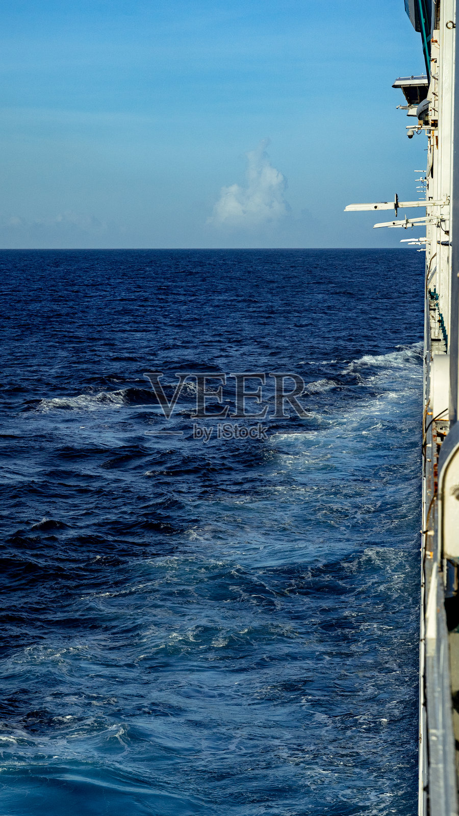 游轮在湛蓝的海洋上航行，留下一串尾迹照片摄影图片