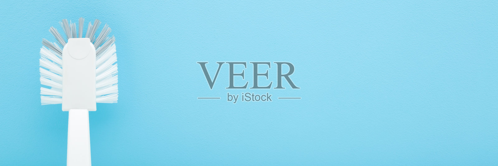 浅蓝色桌面背景上的全新白色马桶清洁刷。柔和的色彩。特写。宽幅横幅。留有空白文本区域。俯视角度。照片摄影图片