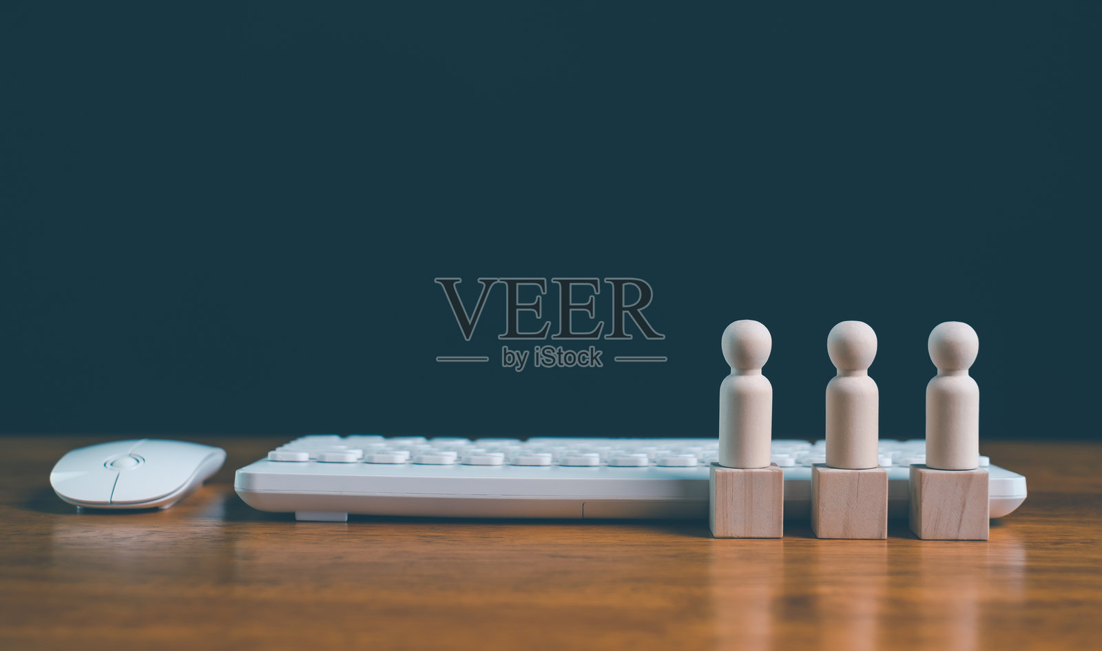 木制人偶站在方块上，旁边是电脑键盘和鼠标，代表办公室团队合作、数字劳动力、远程工作、商业协作、人力资源和现代工作场所。照片摄影图片
