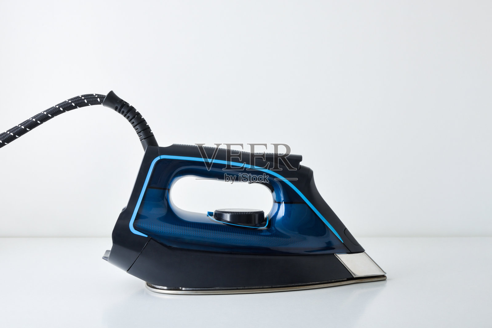 桌子上带倒影的蒸汽熨斗侧视图照片摄影图片