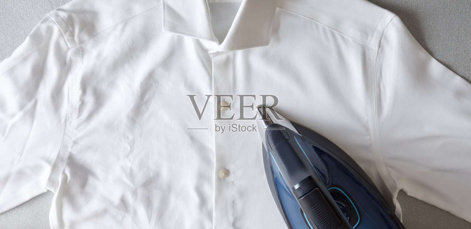 熨烫概念对比，半件熨烫衬衫，熨斗置于上方照片摄影图片