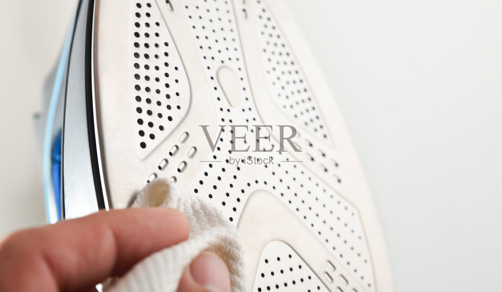 熨斗底板的蒸汽孔和手部清洁照片摄影图片