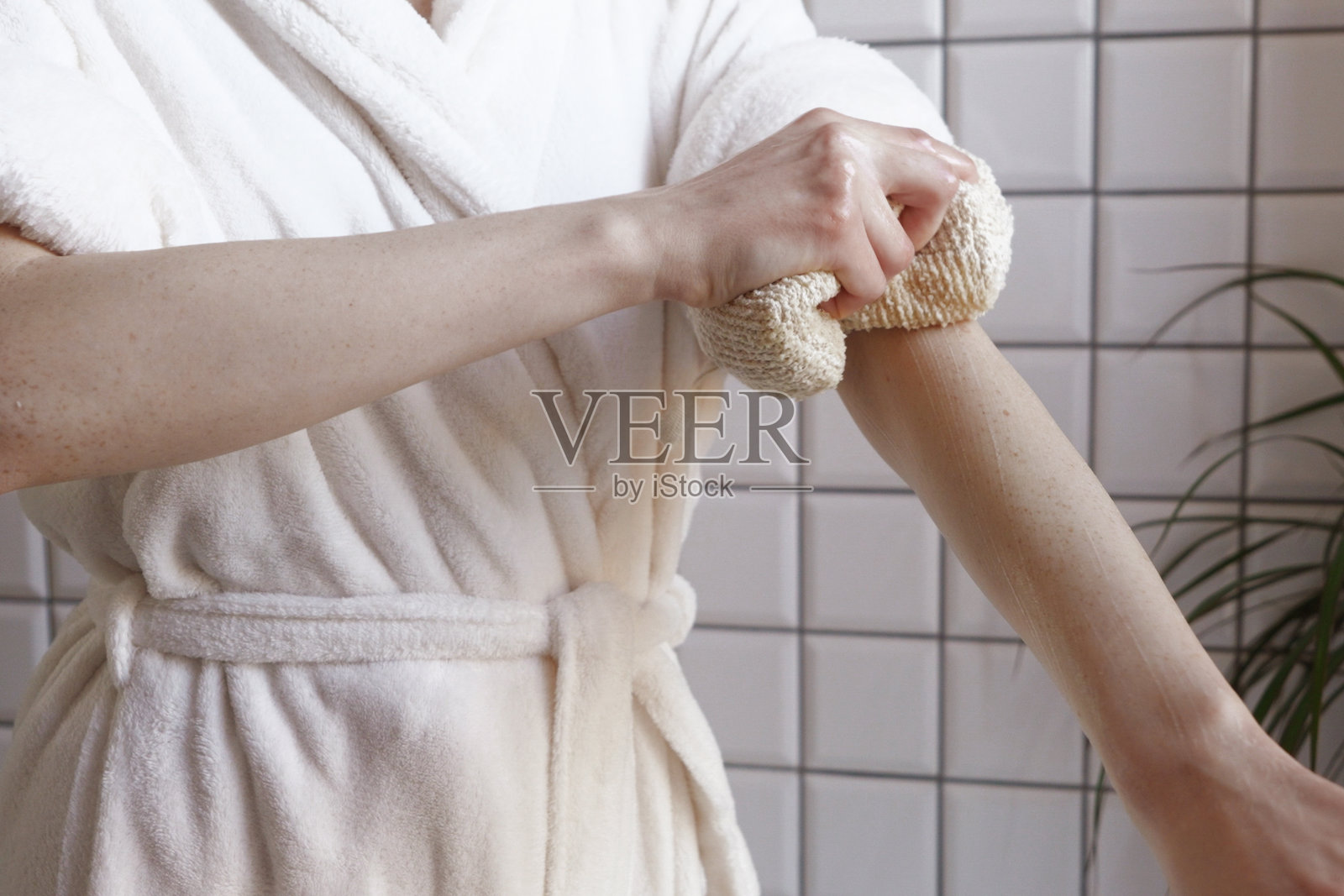 特写：女性在居家水疗环境中用干刷轻扫手臂照片摄影图片