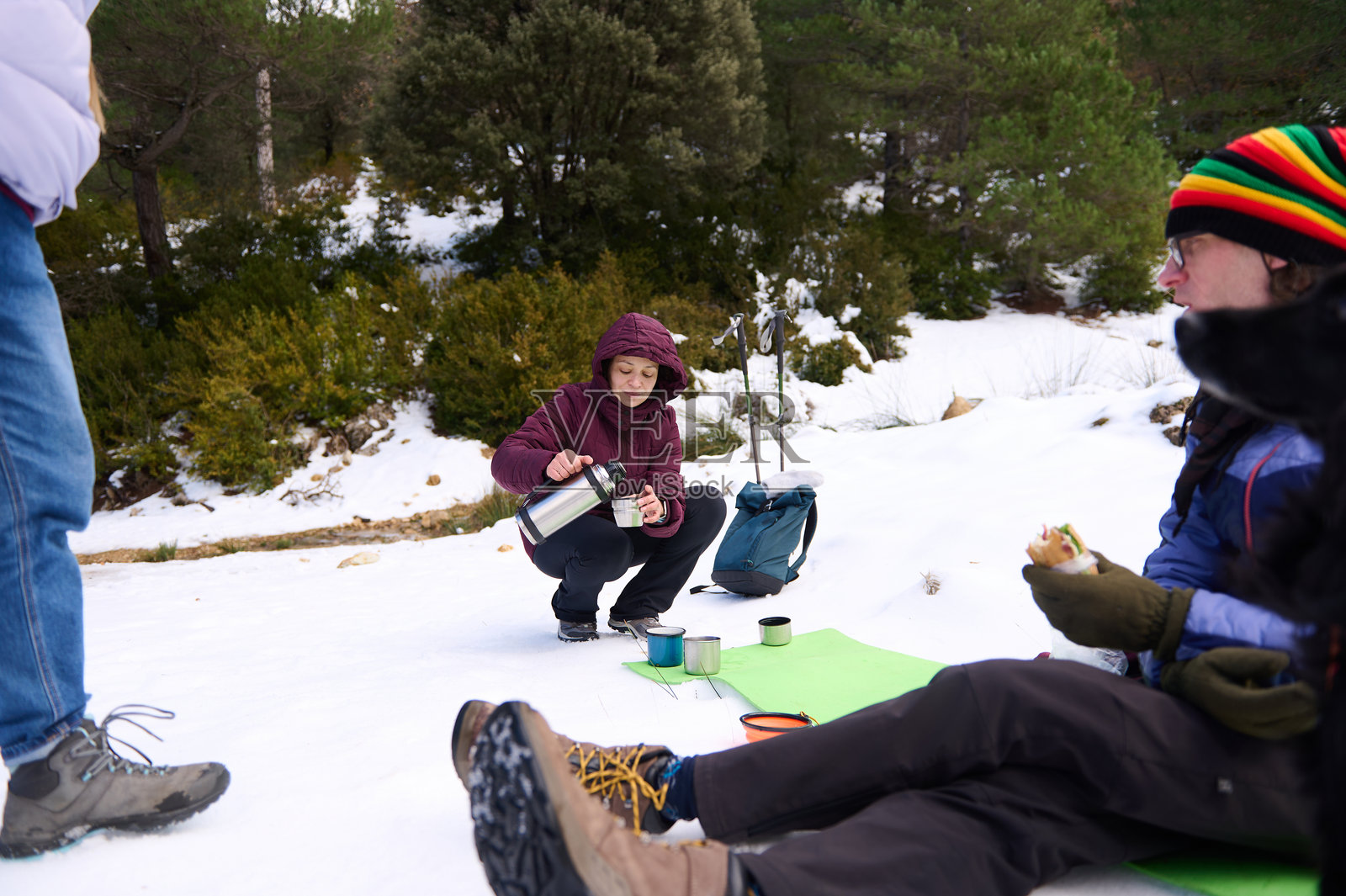 朋友们在雪林徒步中享受寒冷的冬季咖啡休息照片摄影图片