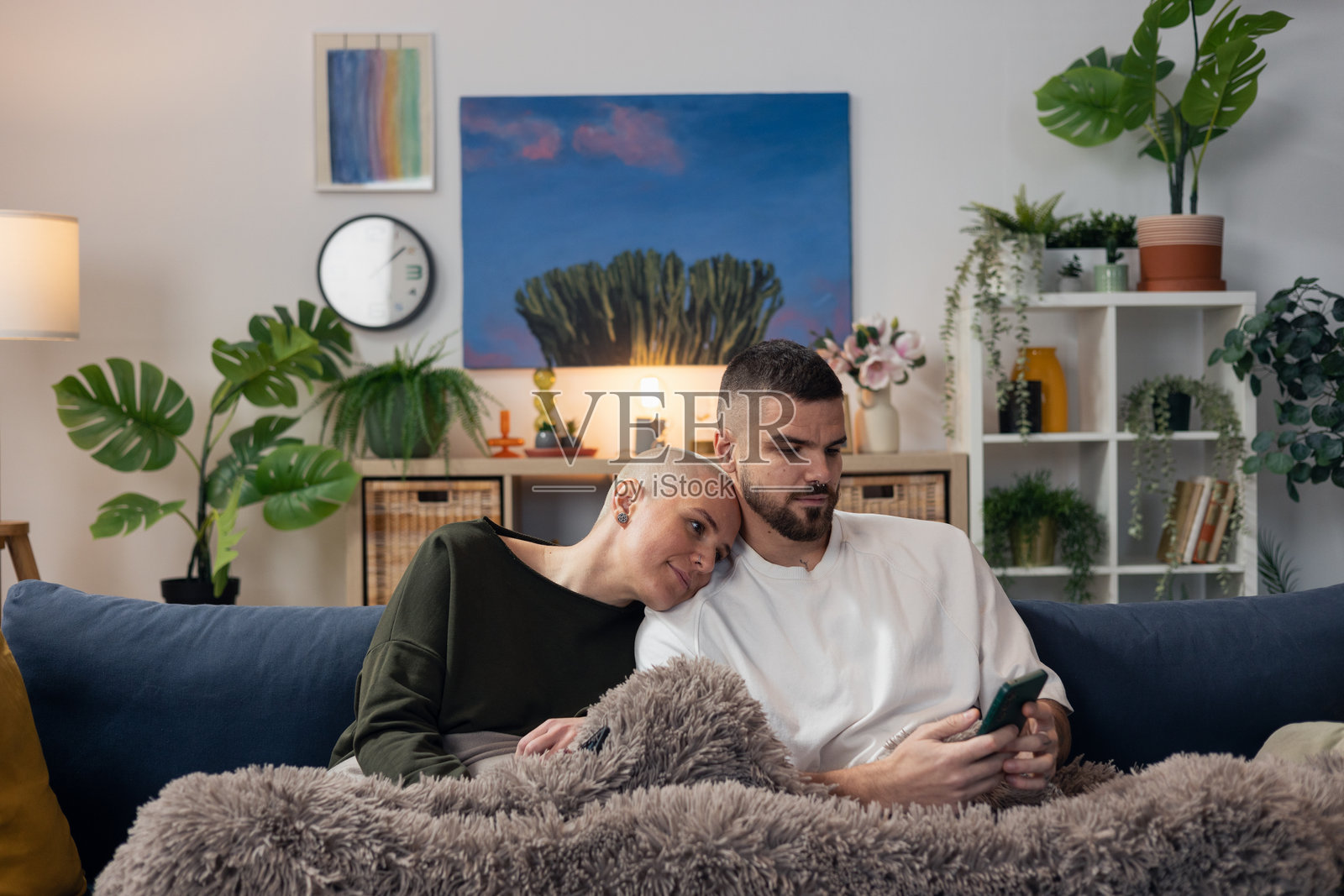 伴侣在沙发上用手机支持一位秃顶女性照片摄影图片