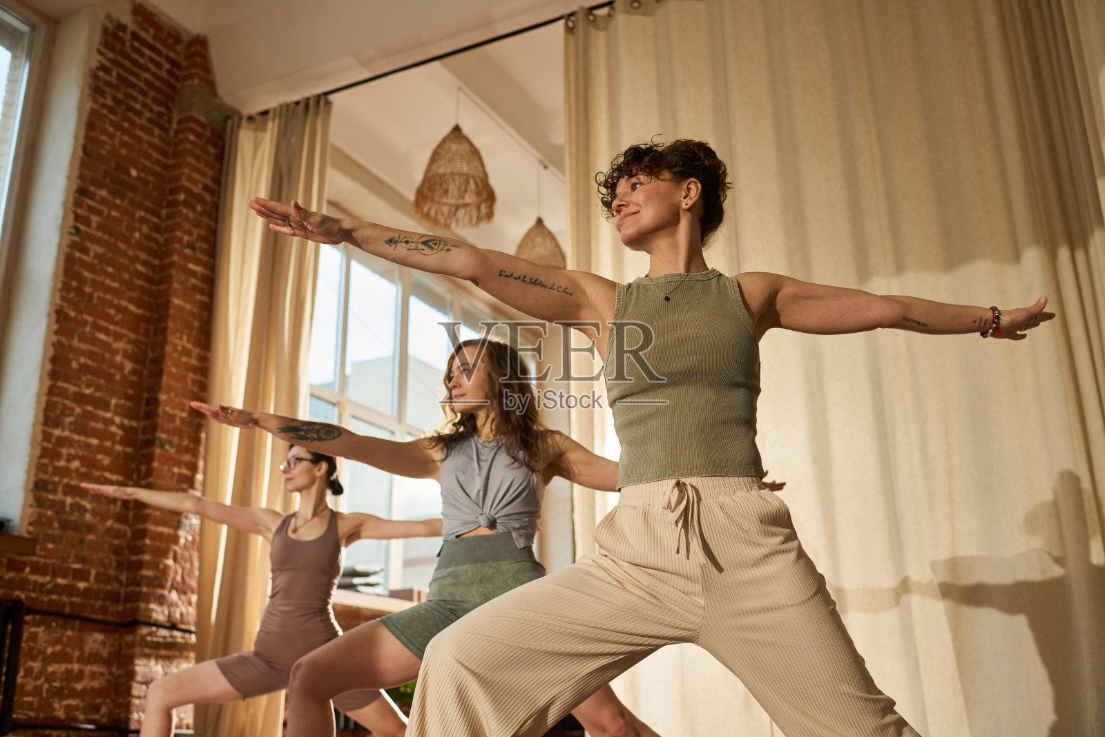 一群年轻的白人女性在室内一起练习瑜伽体式照片摄影图片
