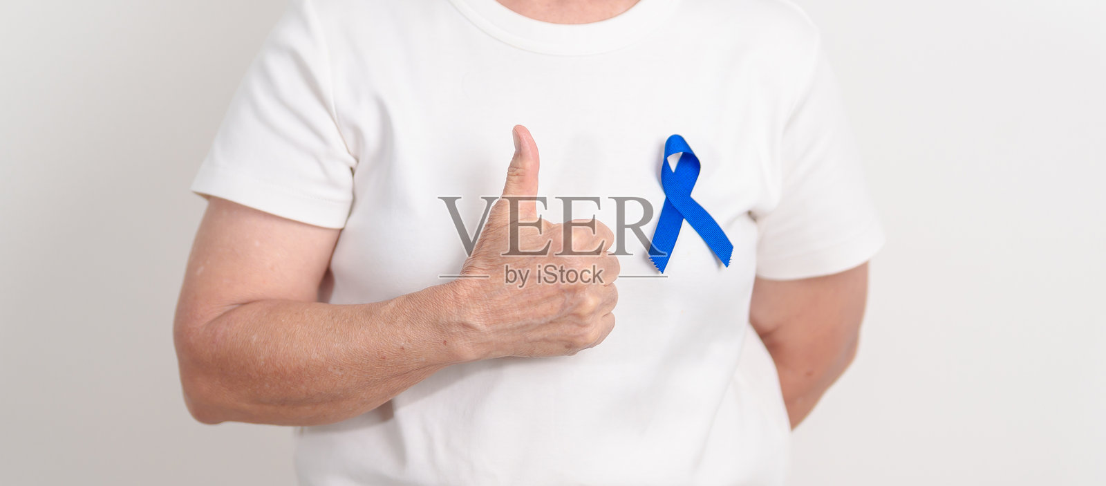 老年人佩戴深蓝色或海军蓝丝带，象征三月结直肠癌和结肠癌宣传月、五月关节炎宣传月、七月青少年关节炎和儿童健康宣传月以及世界癌症日照片摄影图片