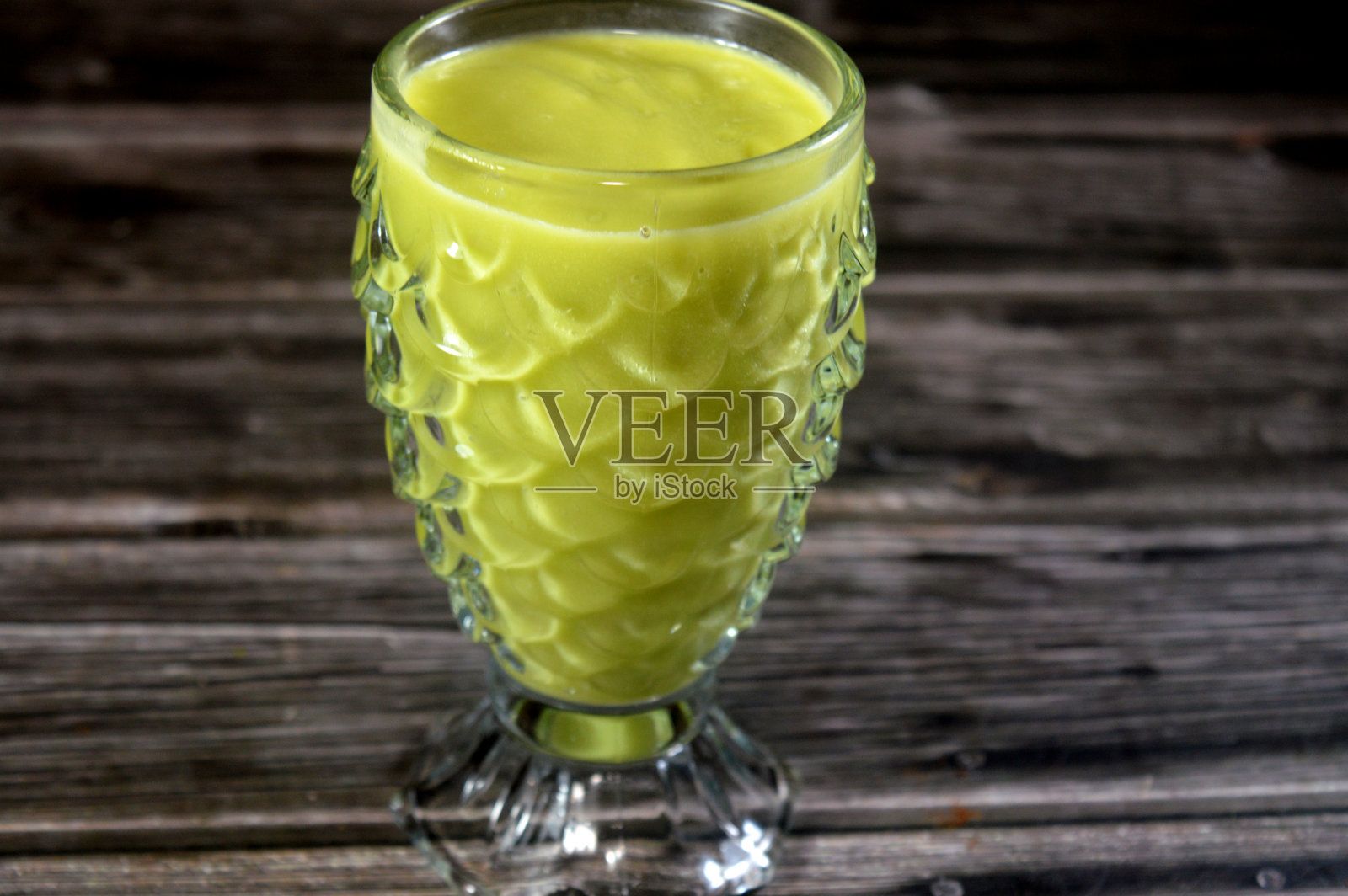 一杯新鲜的牛油果汁，一种营养丰富的[_T_],在植物学上是一种大型浆果，以其奶油般的质地、健康的脂肪（主要是单不饱和脂肪）和纤维而闻名。照片摄影图片