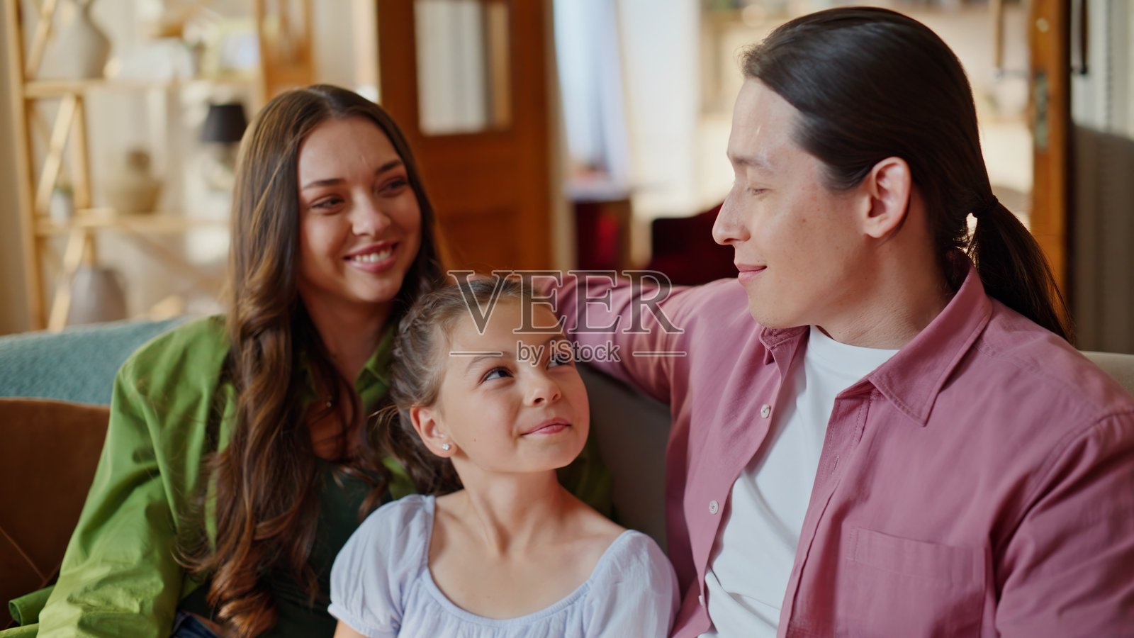 特写：一家人在客厅沙发上拥抱在一起看喜剧照片摄影图片