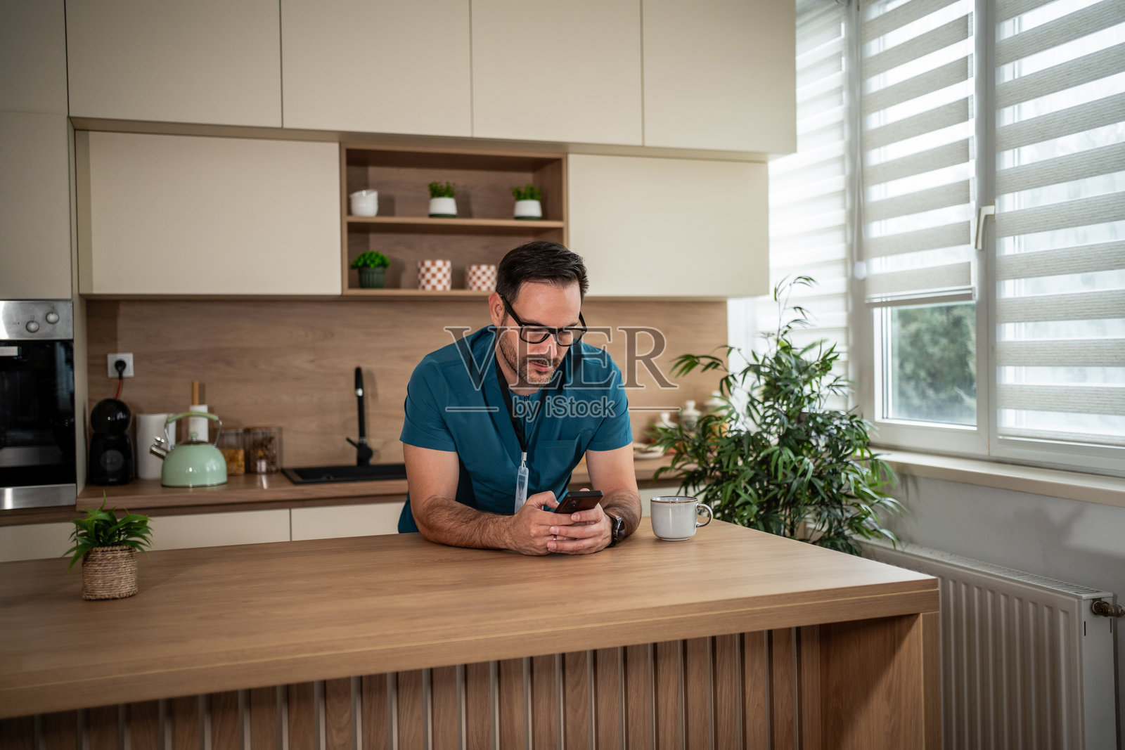 医护人员在厨房里喝咖啡、看手机放松照片摄影图片