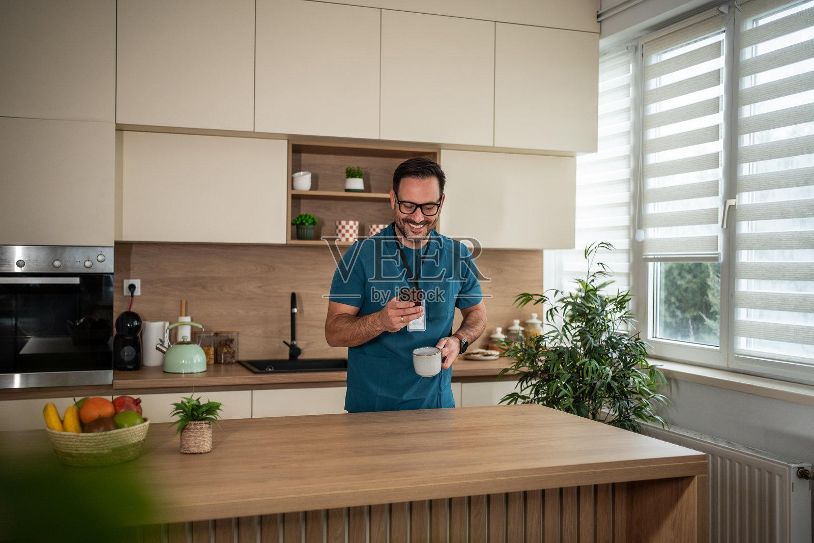 医护人员在厨房休息时用手机喝咖啡照片摄影图片