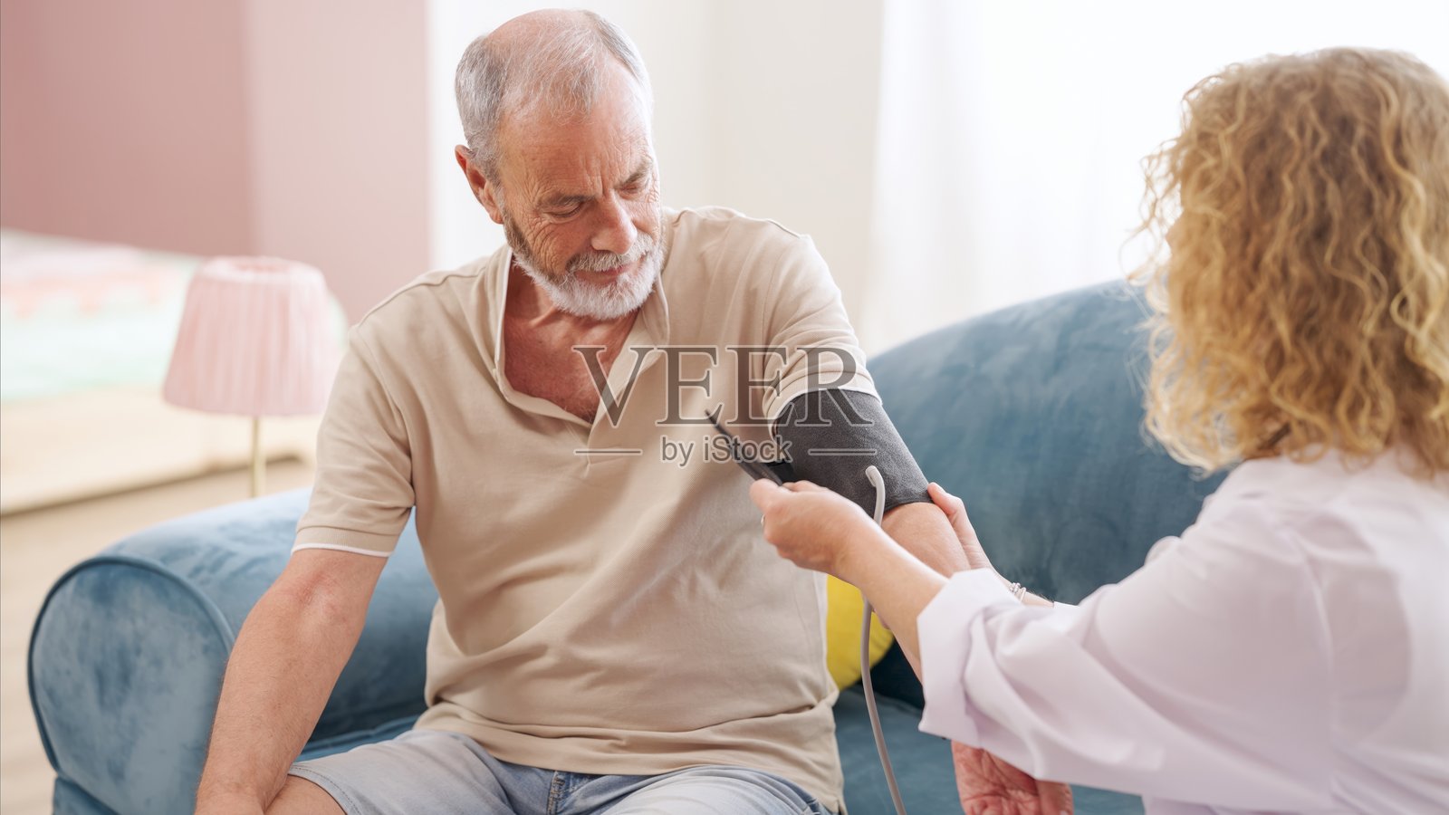 女医生在家为老人量血压照片摄影图片