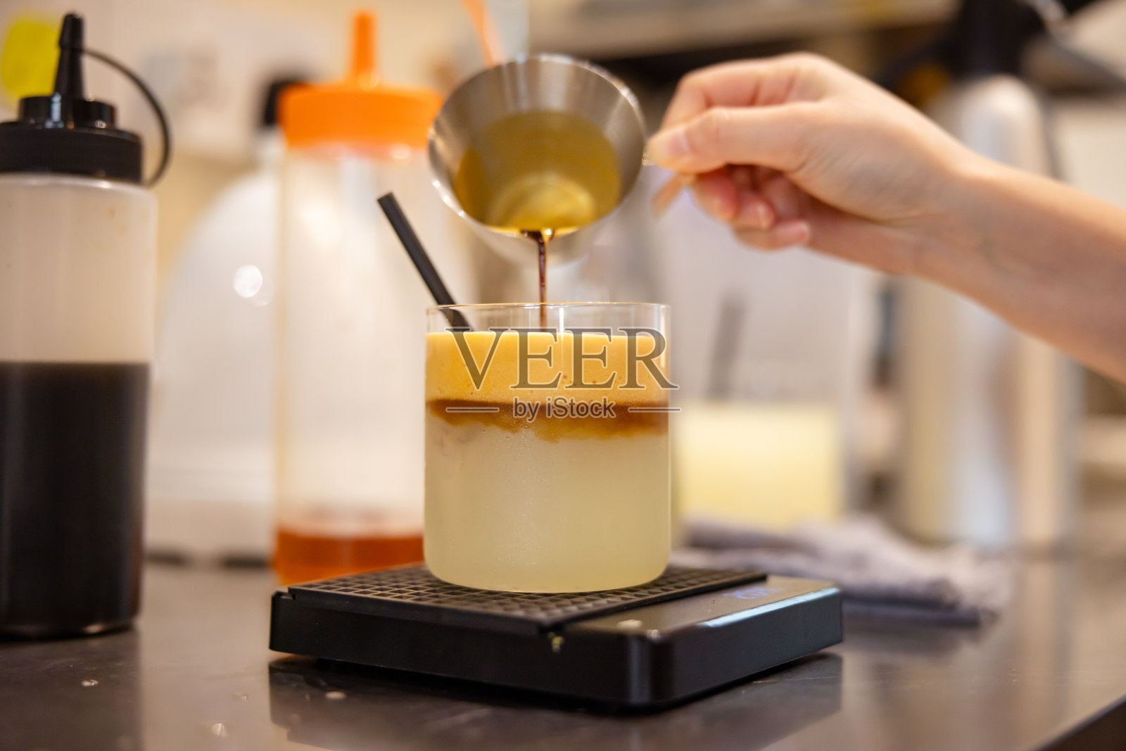 女咖啡师正在准备加入柠檬汁的新鲜浓缩咖啡。照片摄影图片