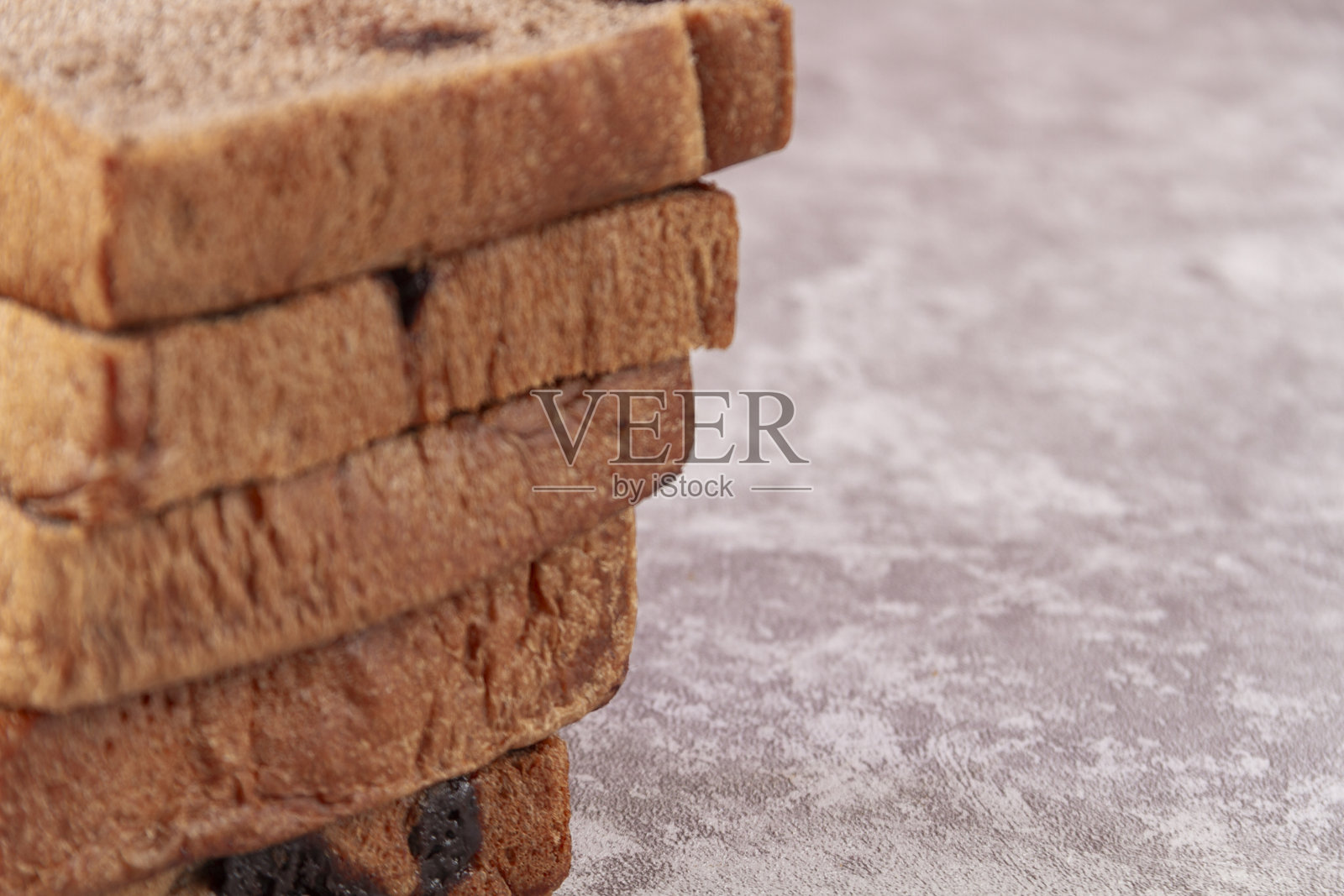 深色巧克力日式吐司（生吐司），表面带有巧克力碎，置于水泥表面上照片摄影图片