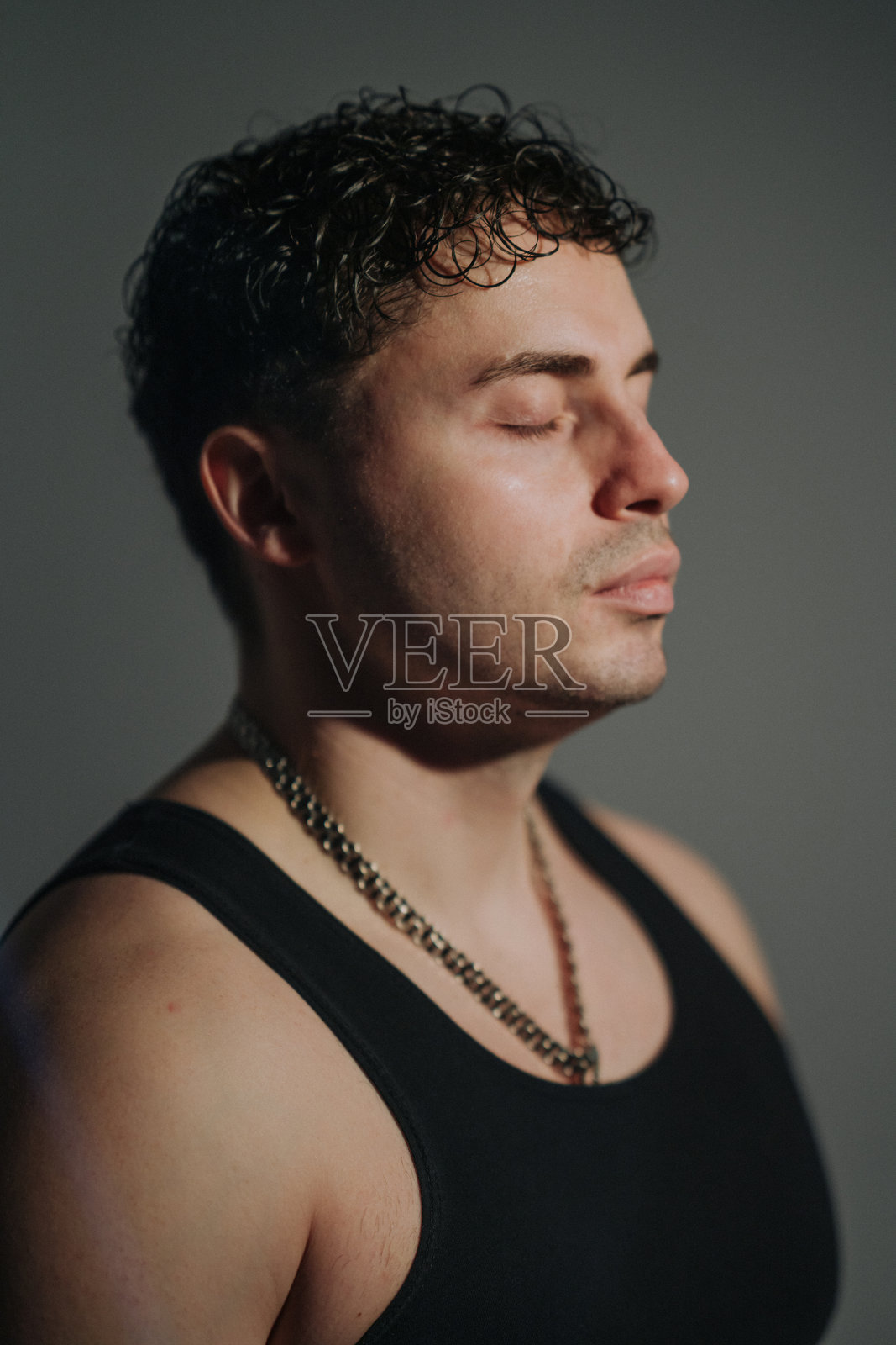 男模特在影棚中展现专注和坚韧照片摄影图片