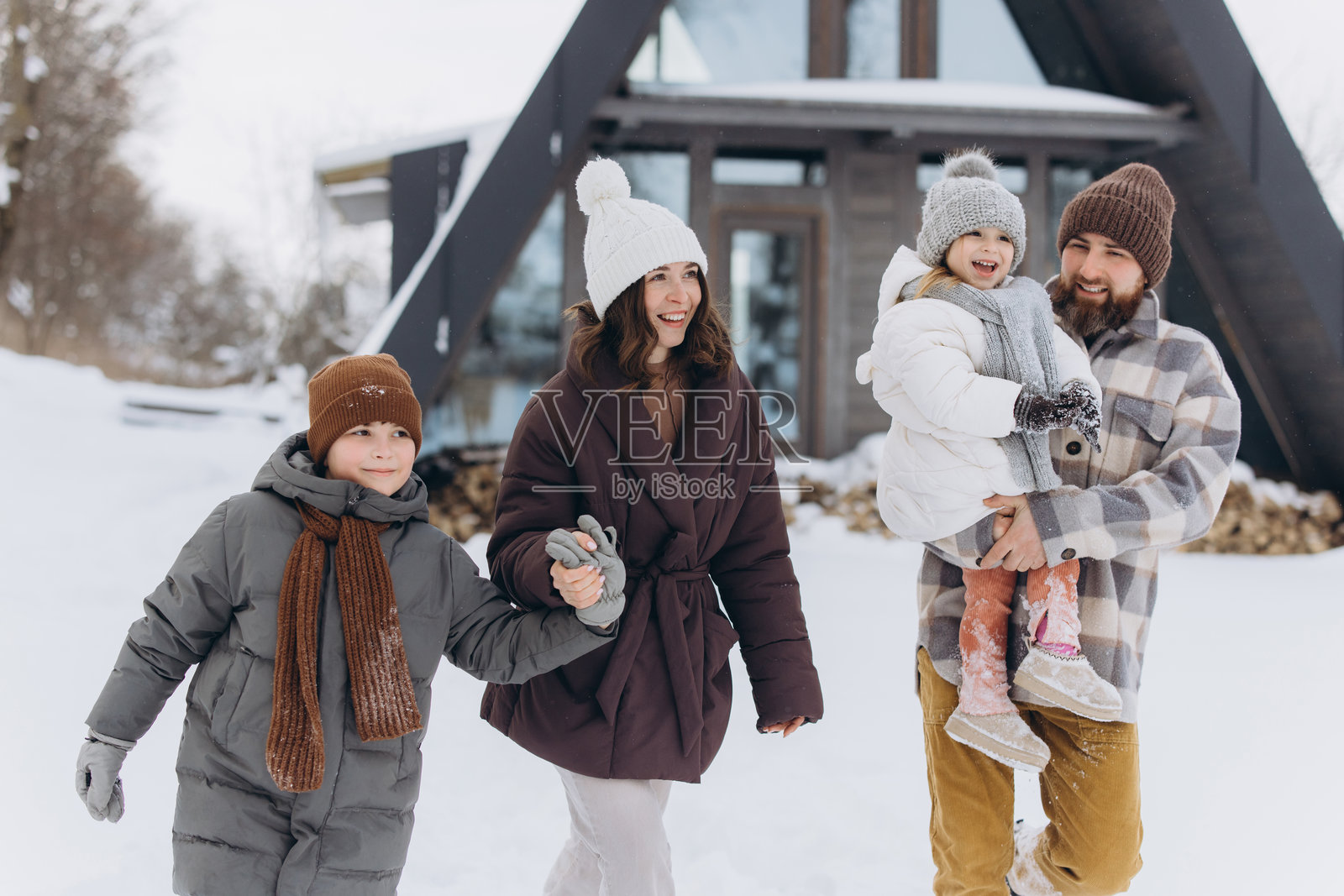 一家人享受冬季假期，在雪中散步照片摄影图片