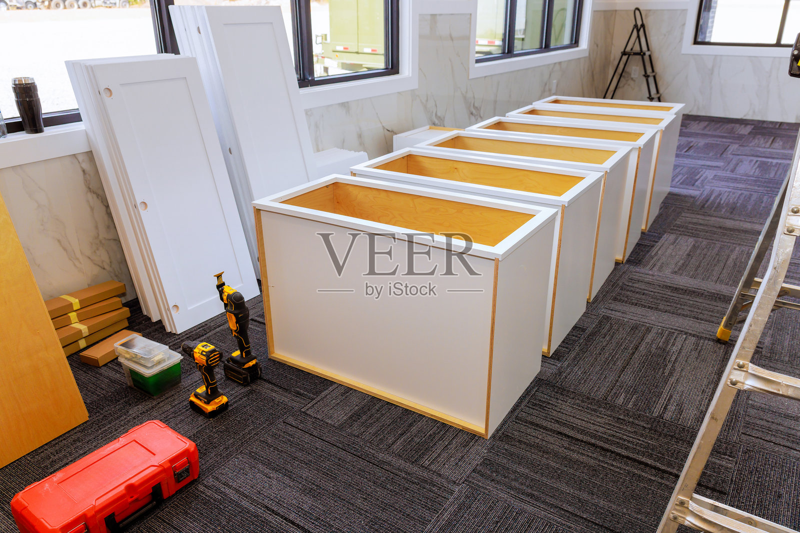 建筑工人在明亮空旷的房间里组装储物单元照片摄影图片