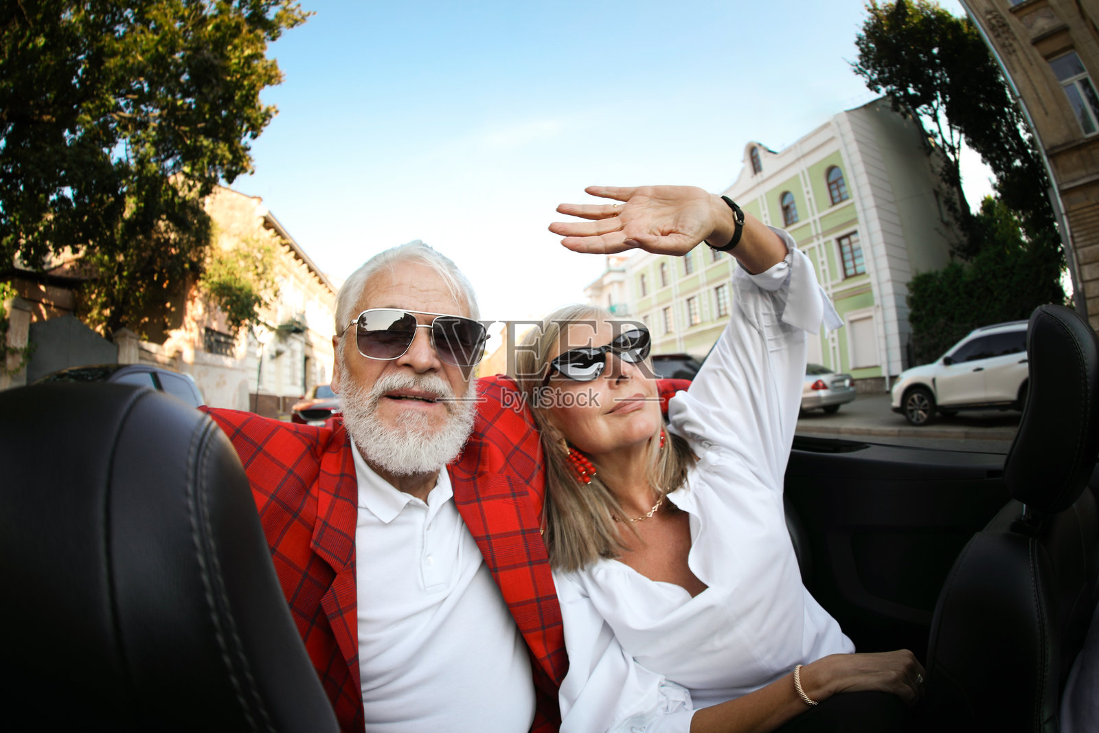 老年夫妇在城市中享受敞篷车之旅，广角镜头照片摄影图片