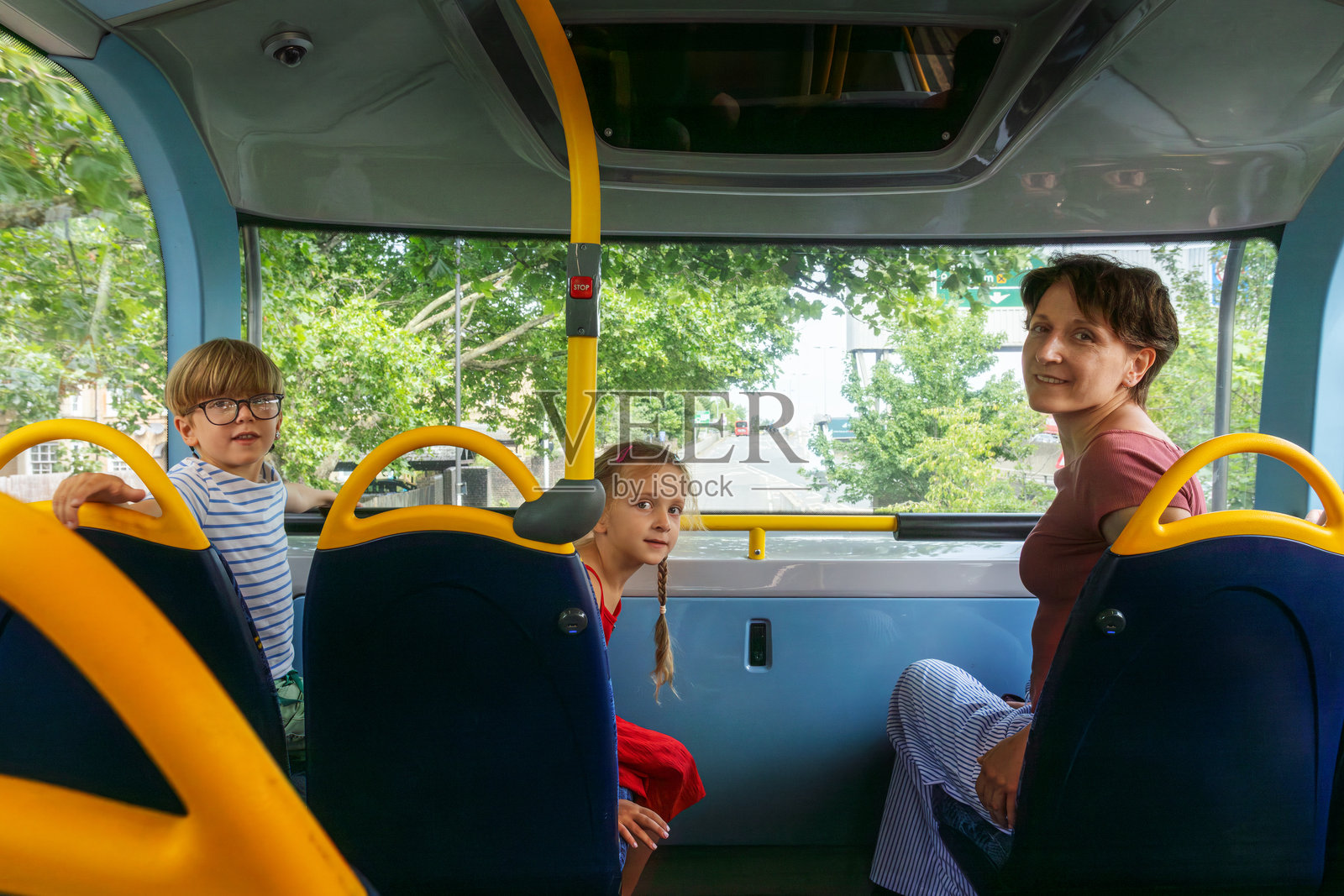 孩子们与一位成年女性在城市中享受愉快的巴士旅程照片摄影图片