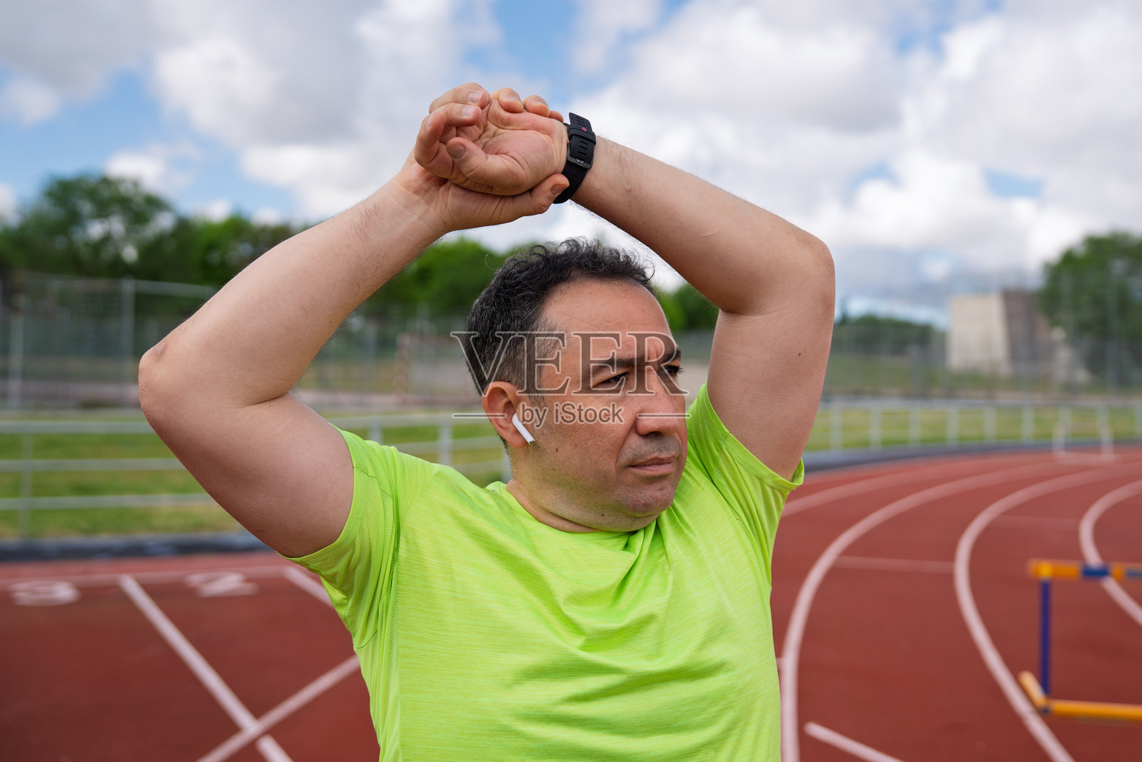成熟的成年运动员在跑道上伸展运动照片摄影图片