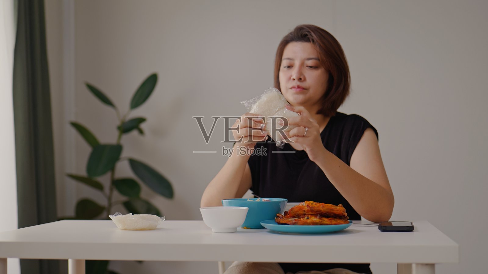 亚洲女性在家吃泰式木瓜沙拉、烤鸡和糯米饭照片摄影图片