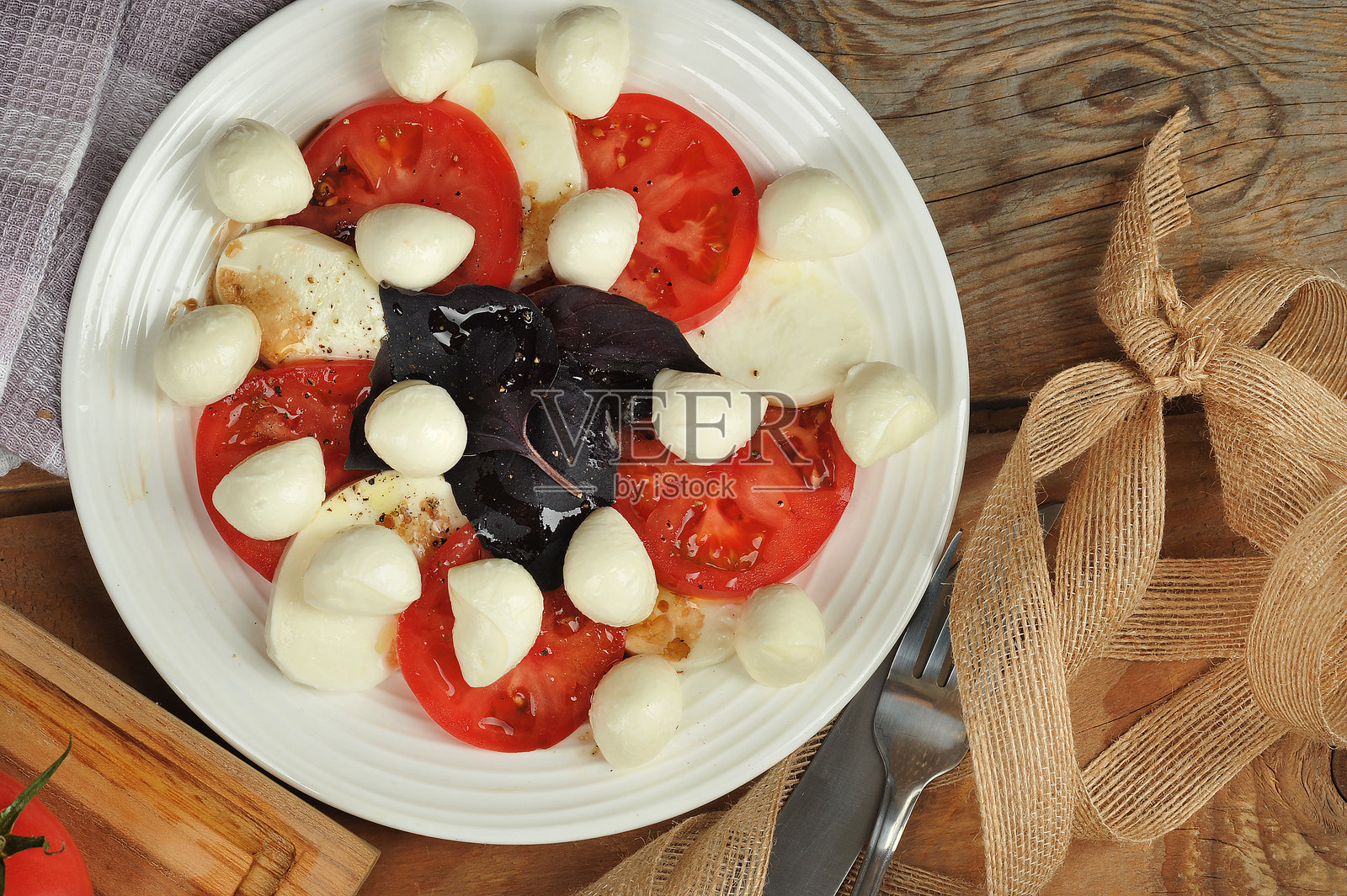 卡普雷塞沙拉——木质背景上的番茄、罗勒和马苏里拉奶酪照片摄影图片