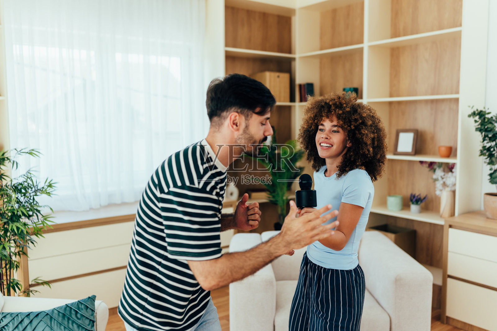 年轻夫妇在家唱卡拉OK照片摄影图片