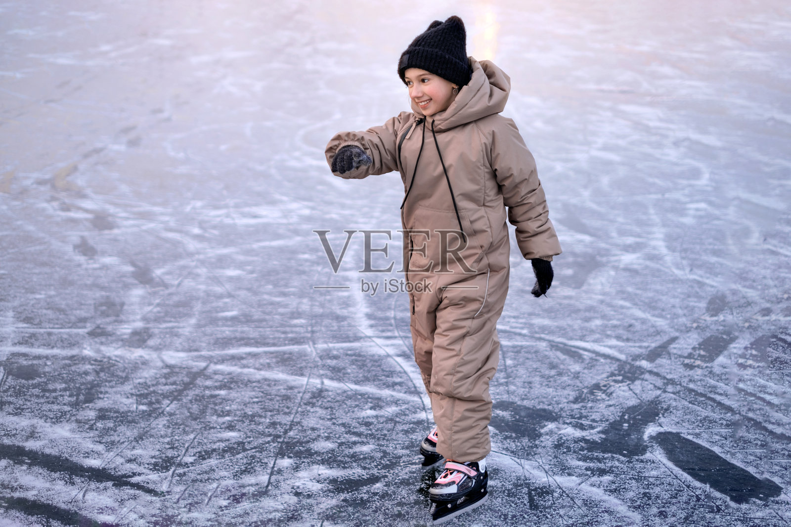 孩子正在冰封湖面上全速滑行，熟练地操控着冰鞋。提升运动技能照片摄影图片