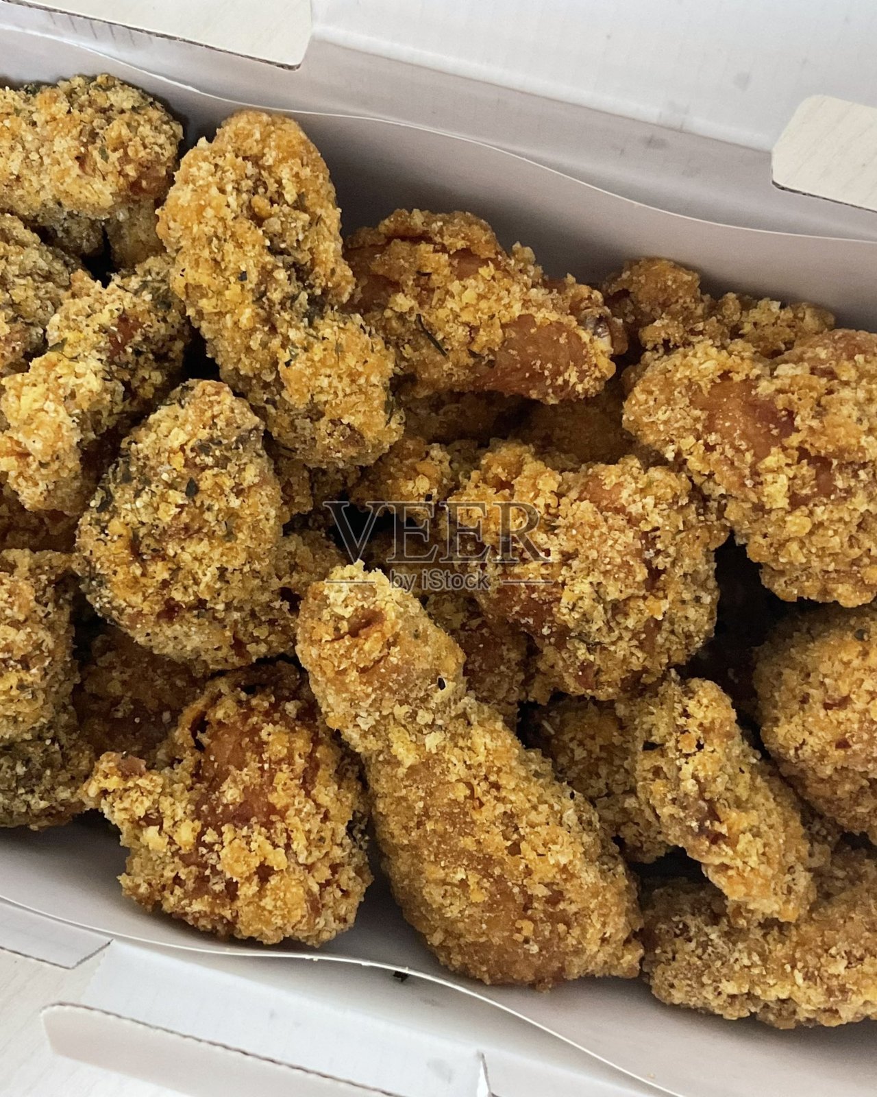 香脆的韩式炸鸡，淋上甜辣酱，口感完美。非常适合美食摄影和菜单，展示这道深受喜爱的菜肴诱人的酥脆口感和风味。照片摄影图片