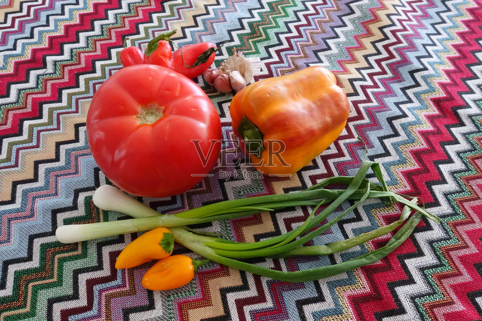 色彩鲜艳的纺织品上精美地摆放着新鲜充满活力的蔬菜照片摄影图片