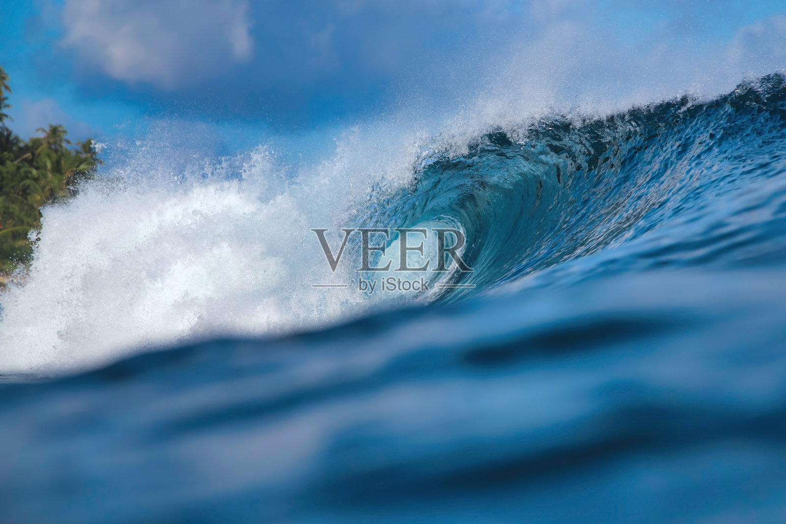 晴朗的天空和耀眼的阳光照亮了巨大的蓝绿色海岸波浪照片摄影图片