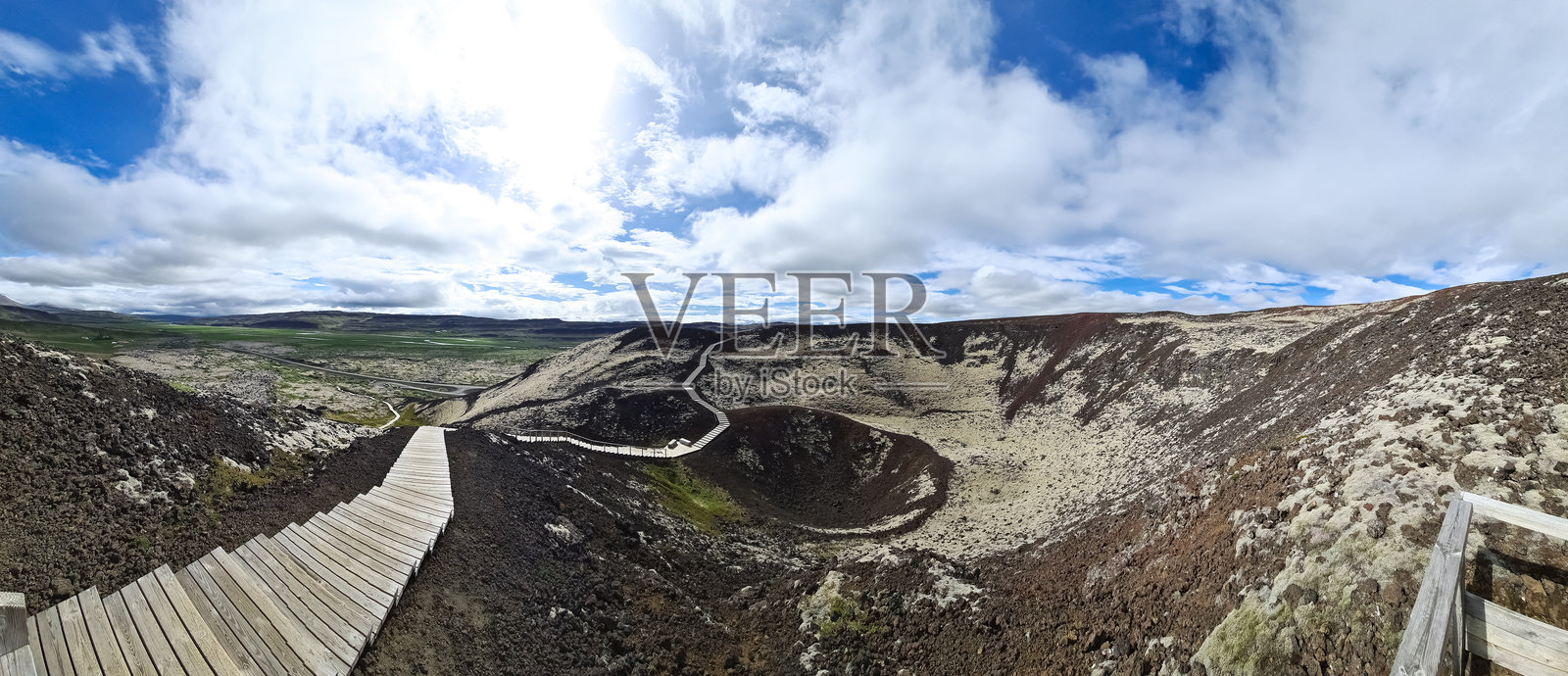 通往冰岛火山坑的木板路，天空多云照片摄影图片