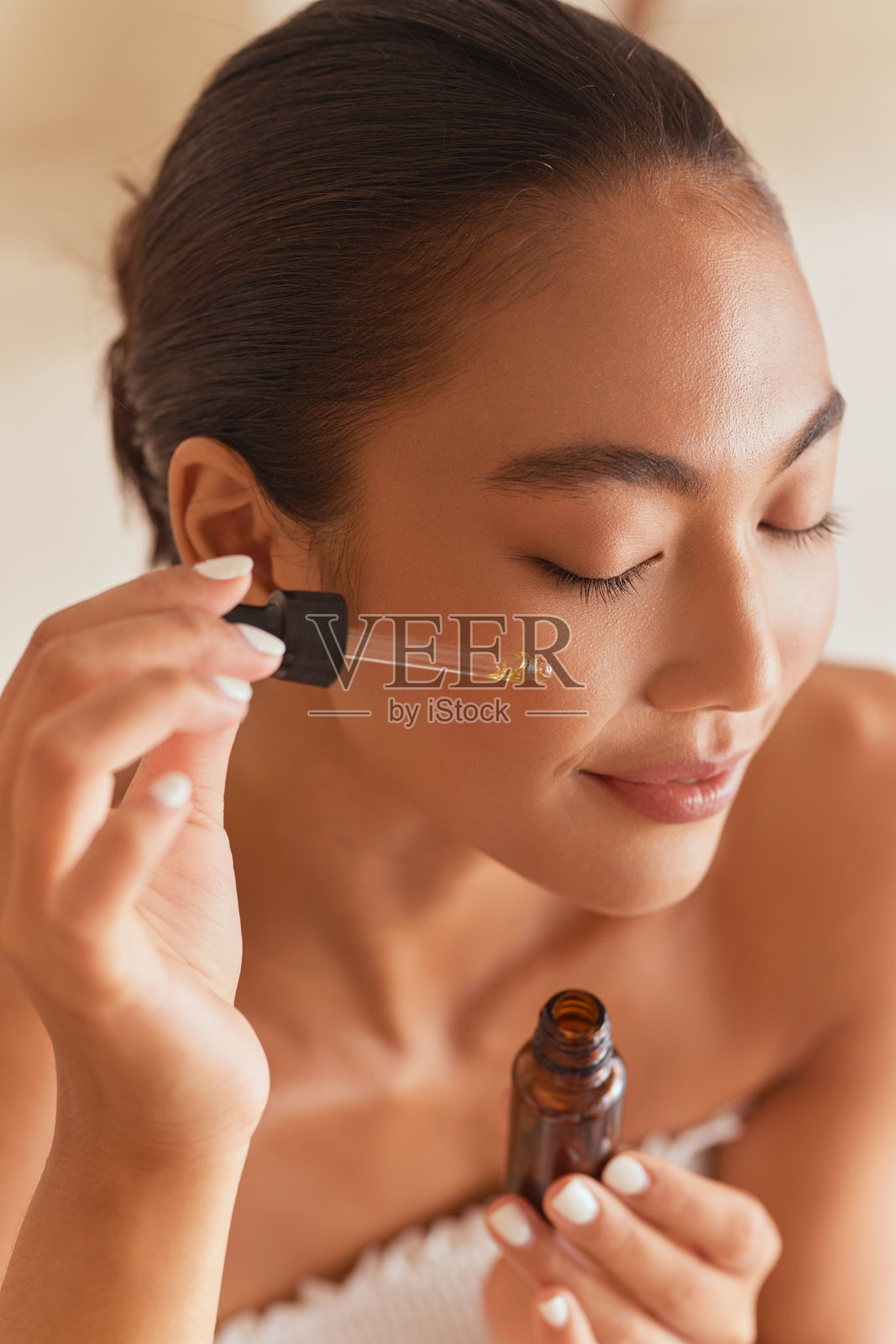 女性涂抹护肤精华，打造健康透亮肌肤照片摄影图片