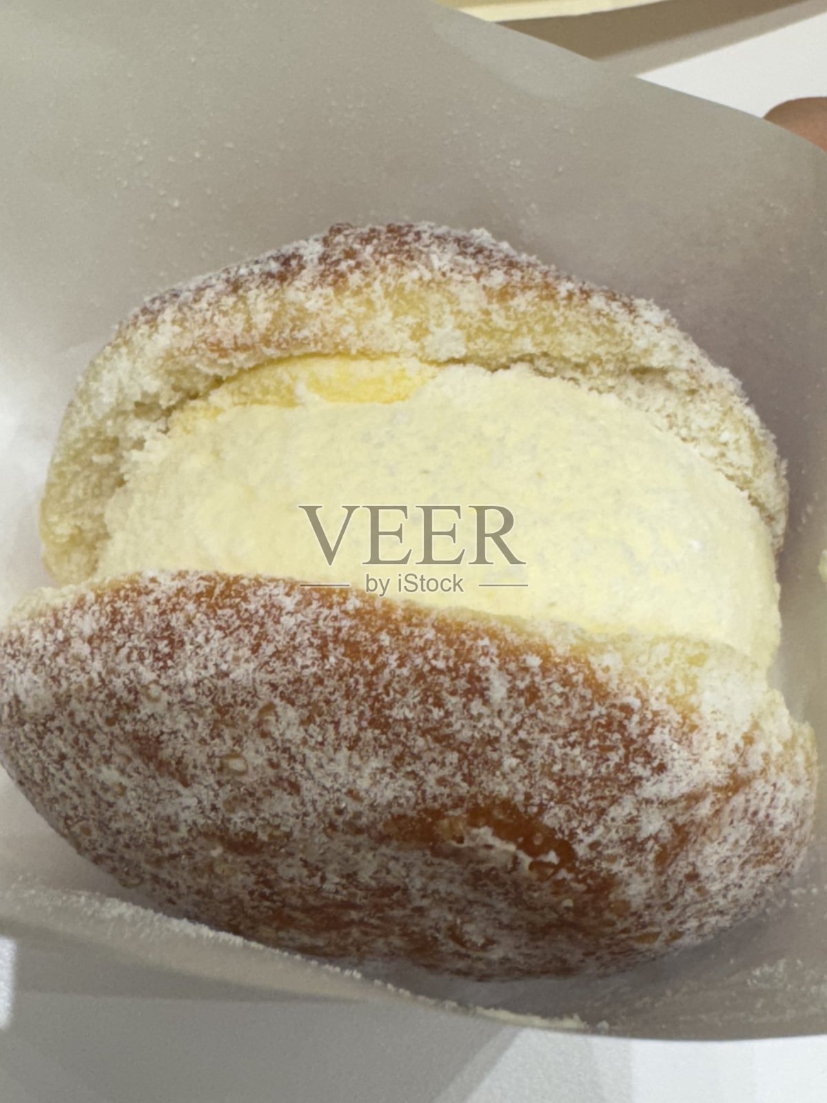 意式甜甜圈Bomboloni，内填奶油卡仕达酱或果酱，撒上糖粉。蓬松而诱人，是完美的甜点，每一口都能品尝到新鲜和温暖。照片摄影图片