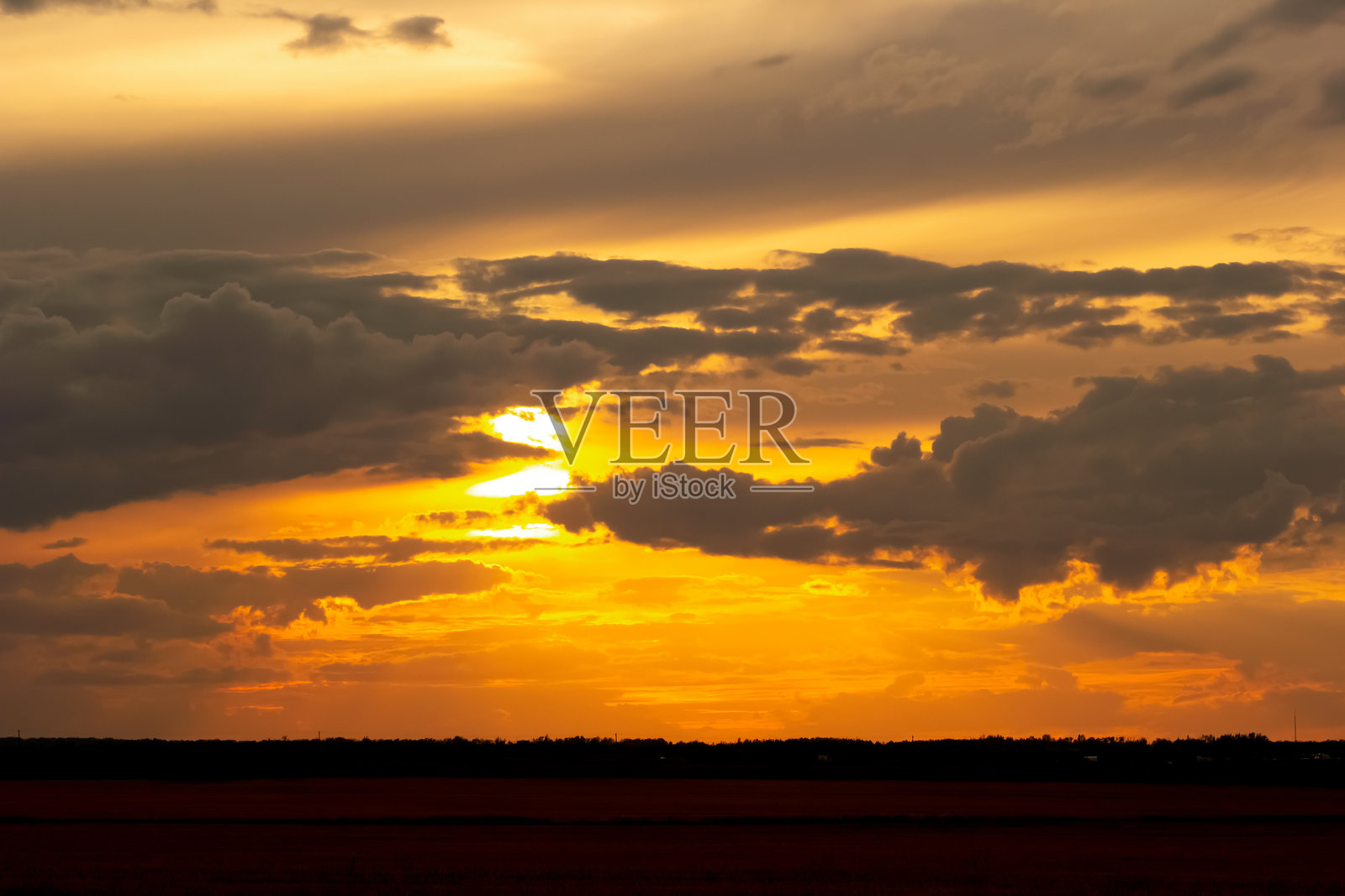 秋日草原上空，橙色戏剧性的日落光芒照片摄影图片