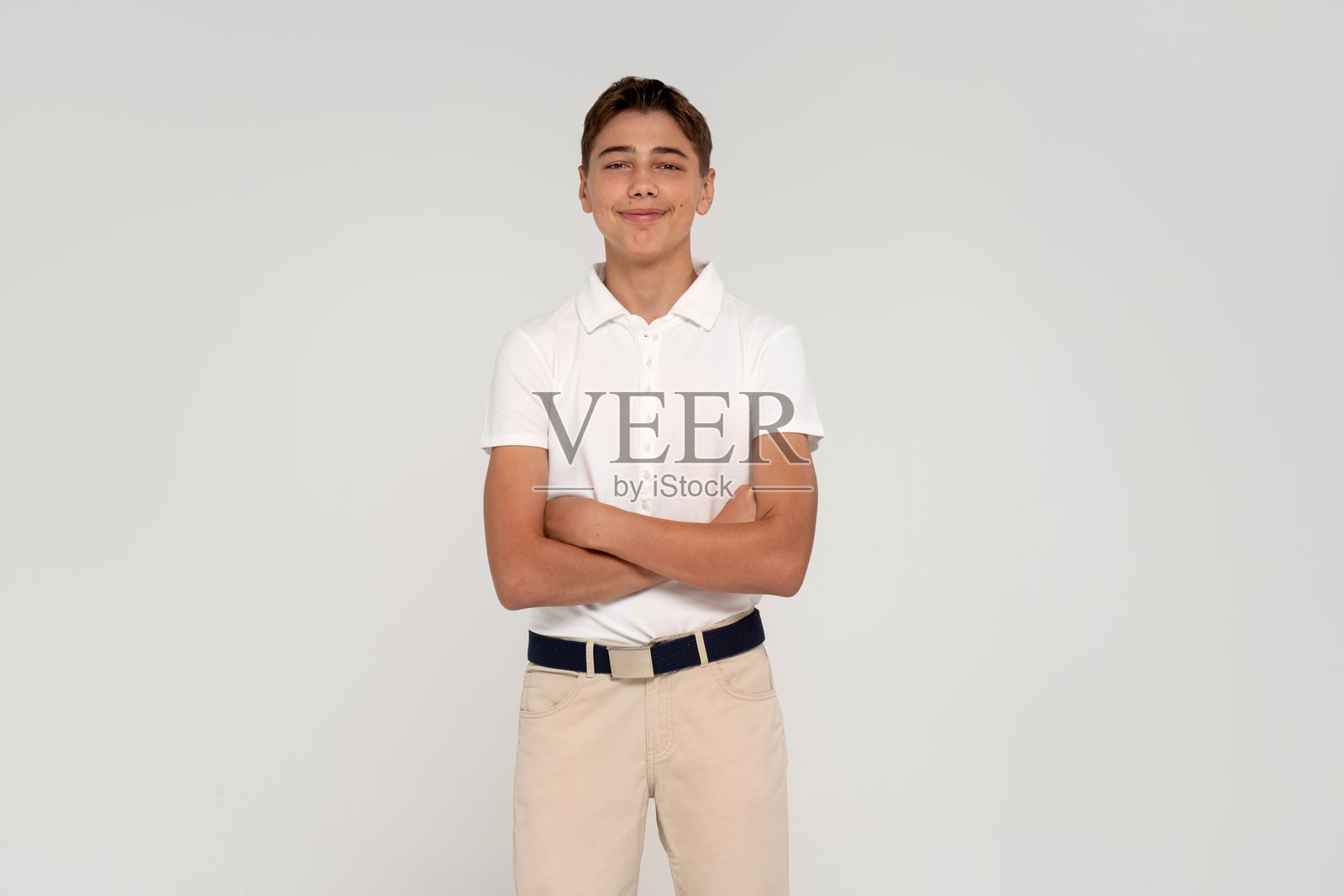 身穿白衬衫的少年，穿着时尚优雅的服装，在影棚摆拍。照片摄影图片