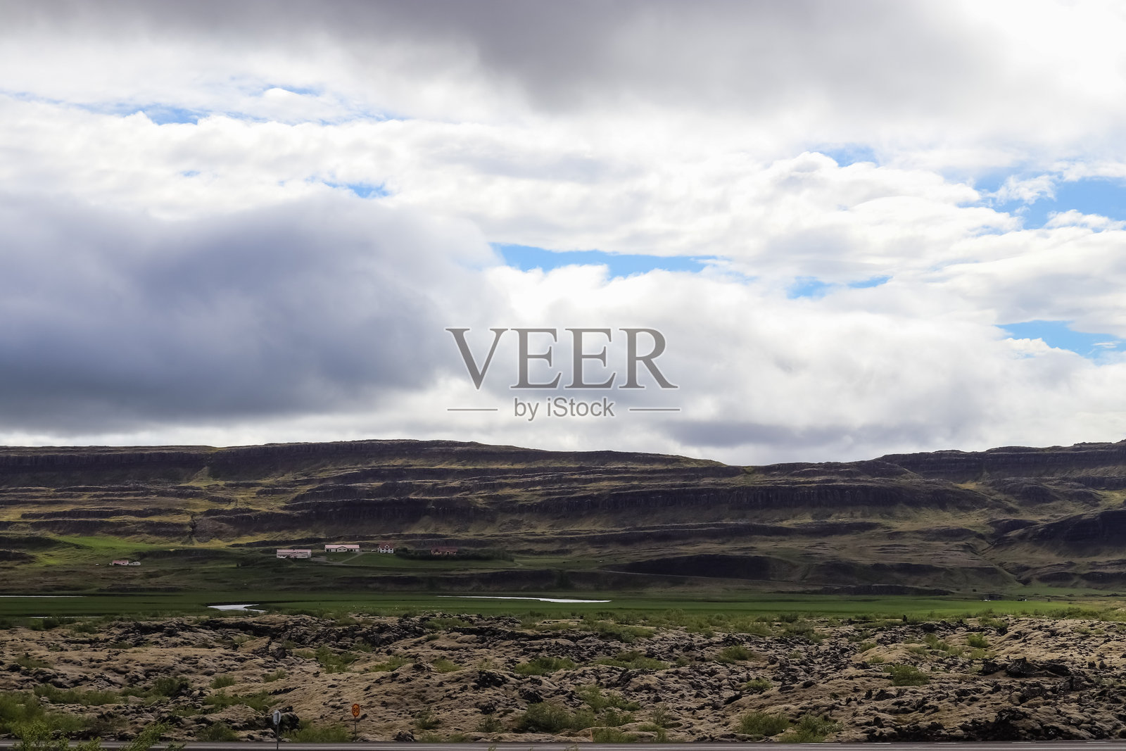 Grabrok火山在多云的天空下主导着冰岛的风景照片摄影图片